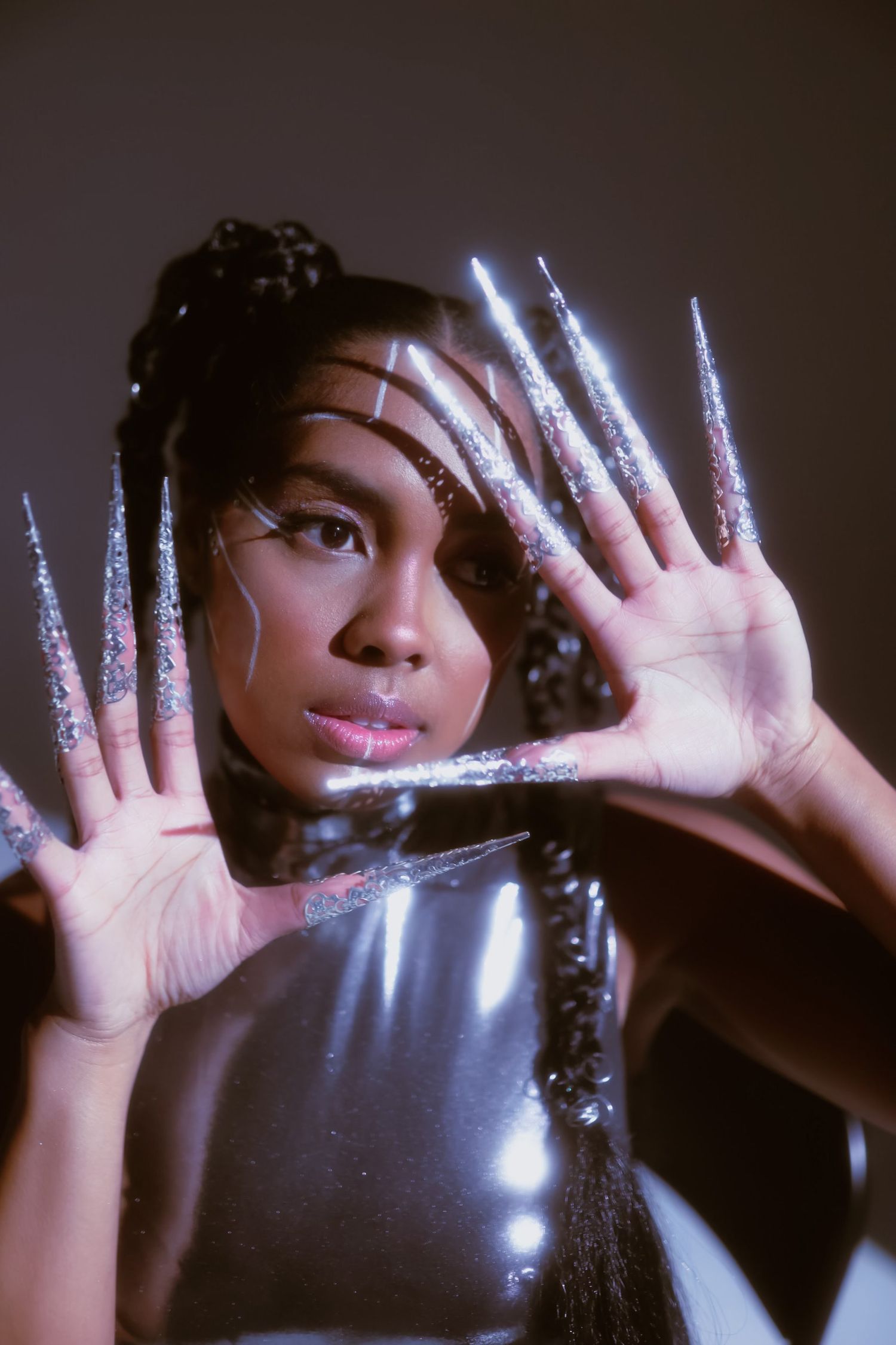 Creative portrait with glowing sparkle effects on hands against dark background.