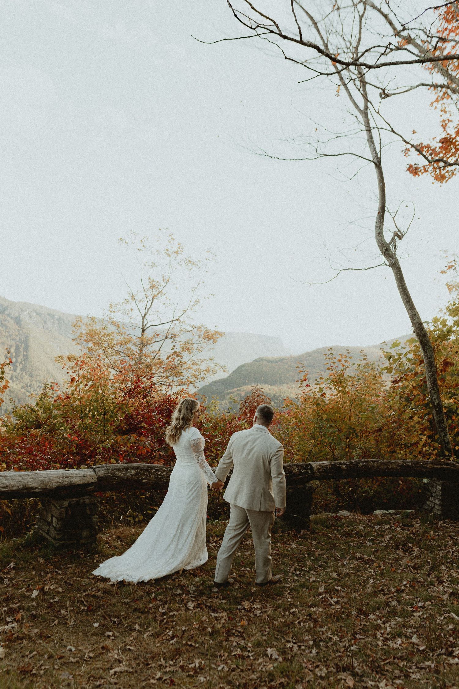 A romantic autumn wedding photo sequence showing a couple walking together on a mountain overlook with fall foliage.