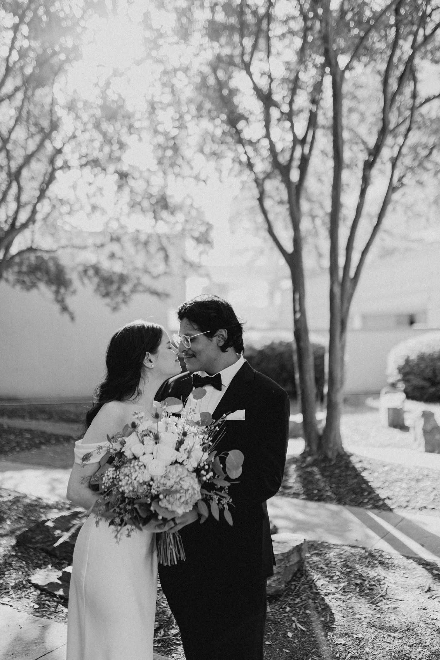 A romantic black and white wedding photo sequence showing a couple sharing intimate moments among trees.