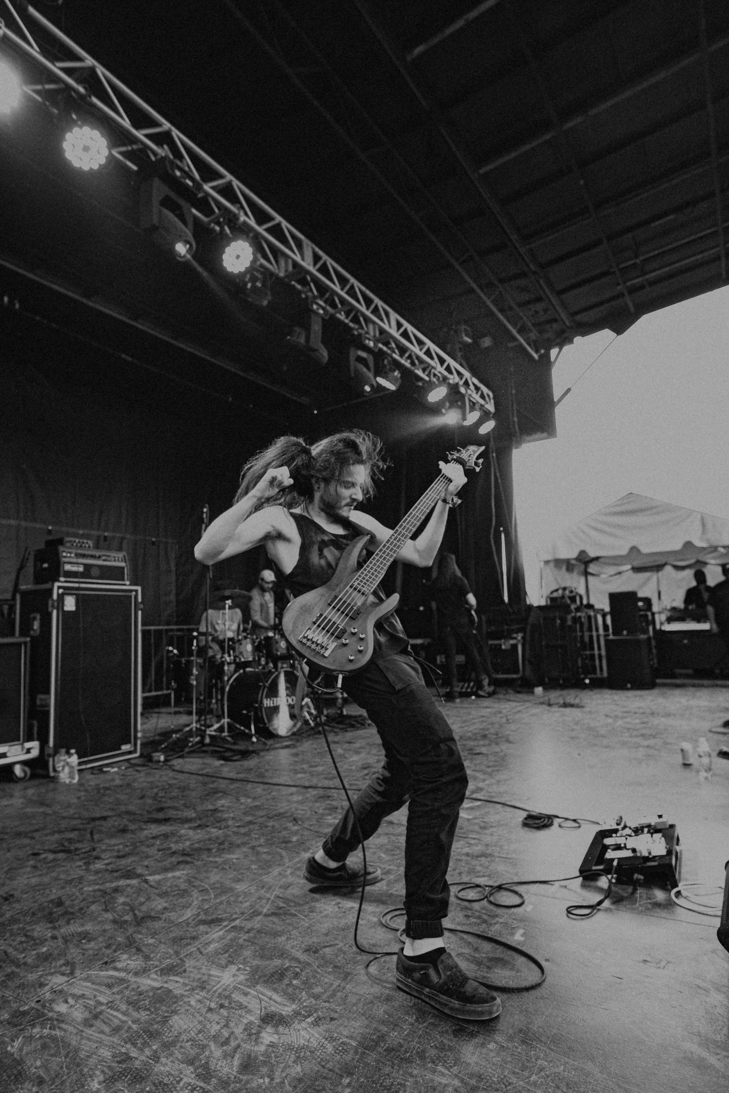 Black and white concert photo capturing high-energy performance movement on stage.