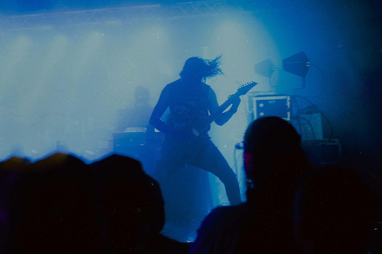 Blue-tinted concert silhouettes with dramatic backlighting creating a moody performance atmosphere.