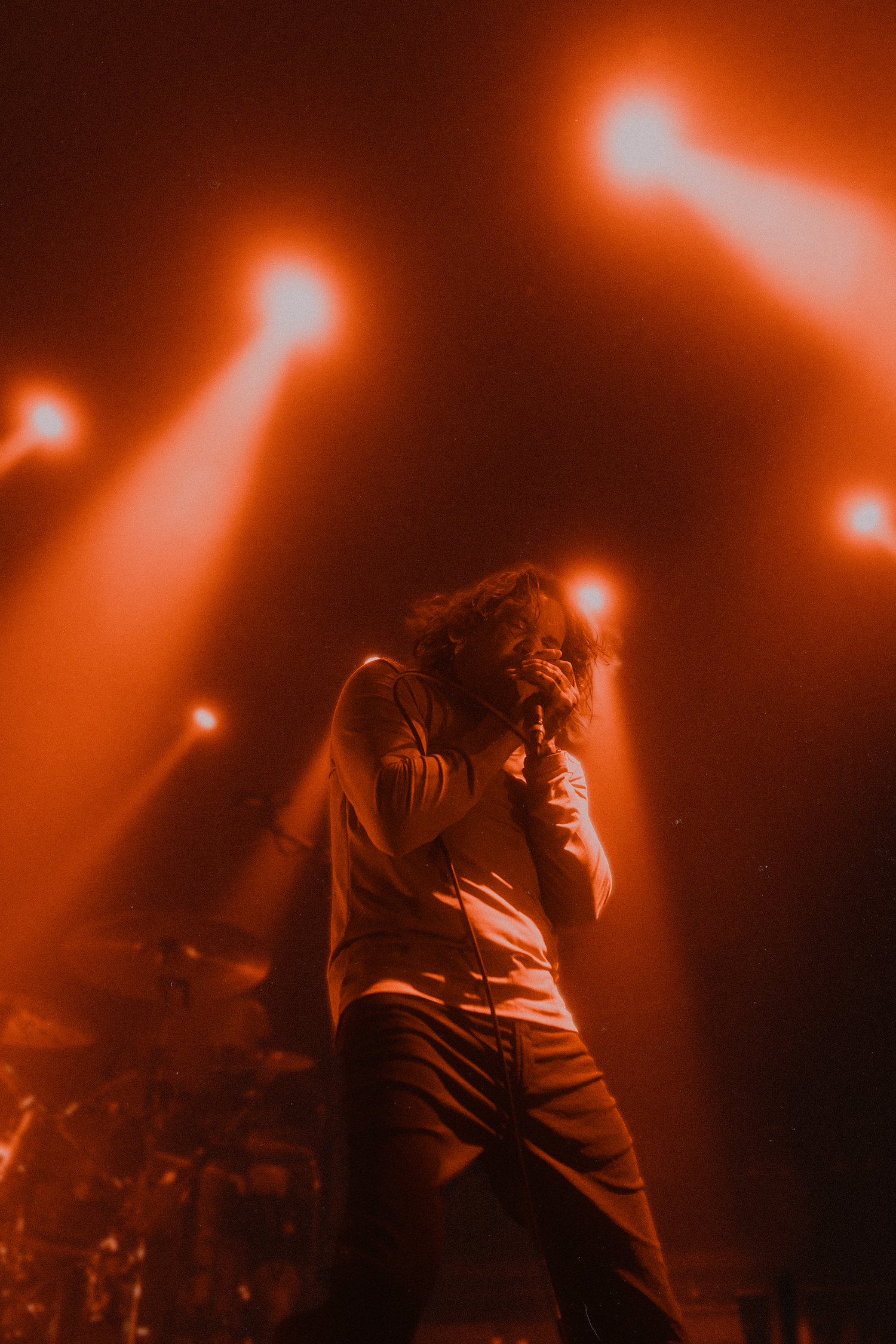 Orange-tinted concert photography captures dynamic movement on stage during a live performance.