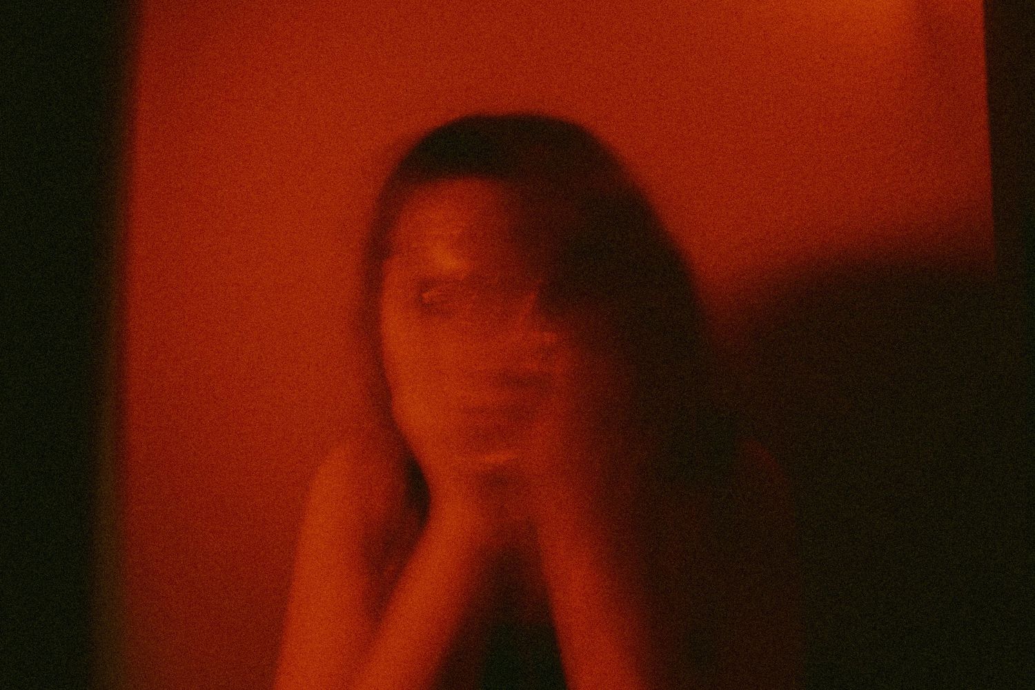Moody red-tinted portrait sequence with dramatic shadows.