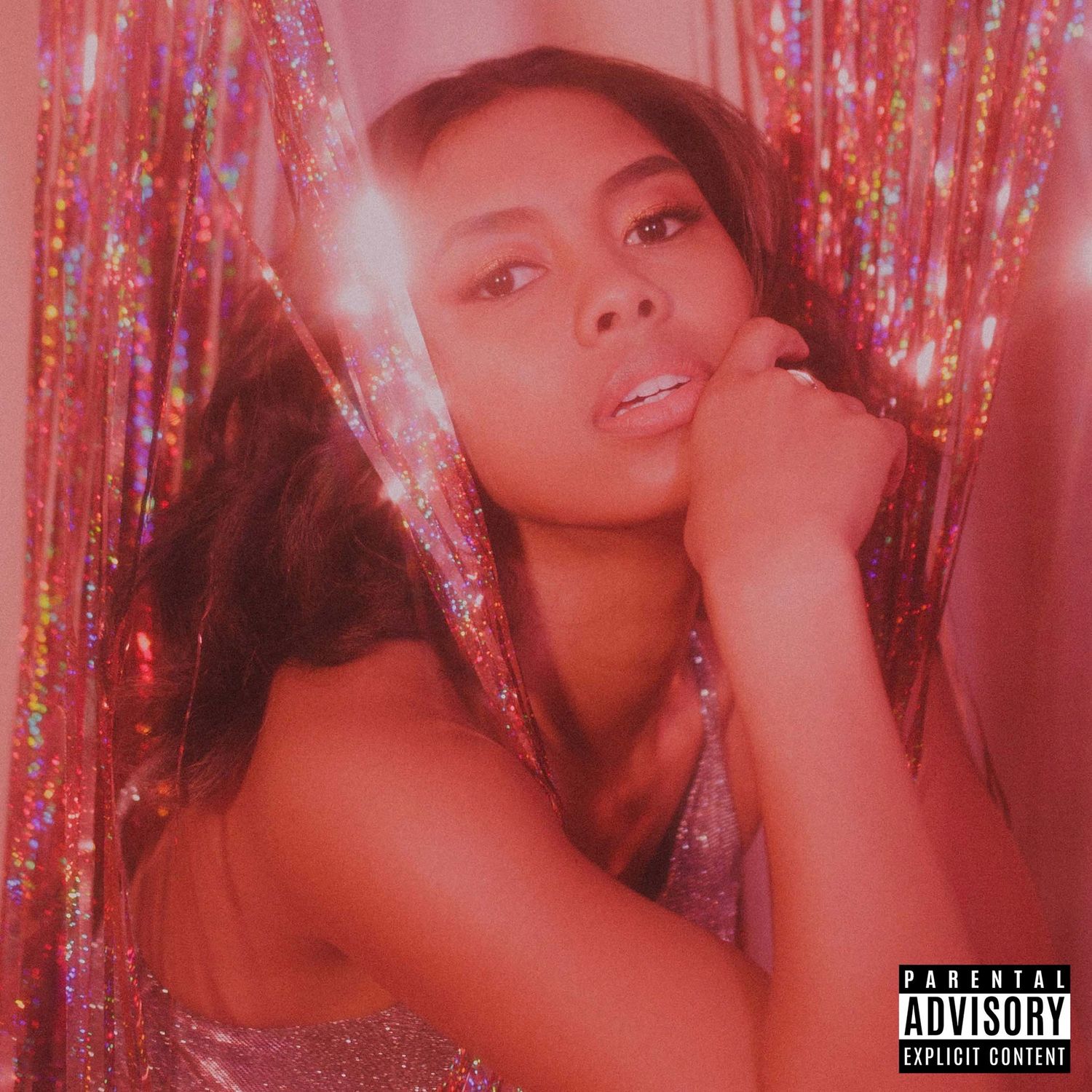 Pink-tinted promotional photo with sparkly tinsel backdrop and parental advisory label.