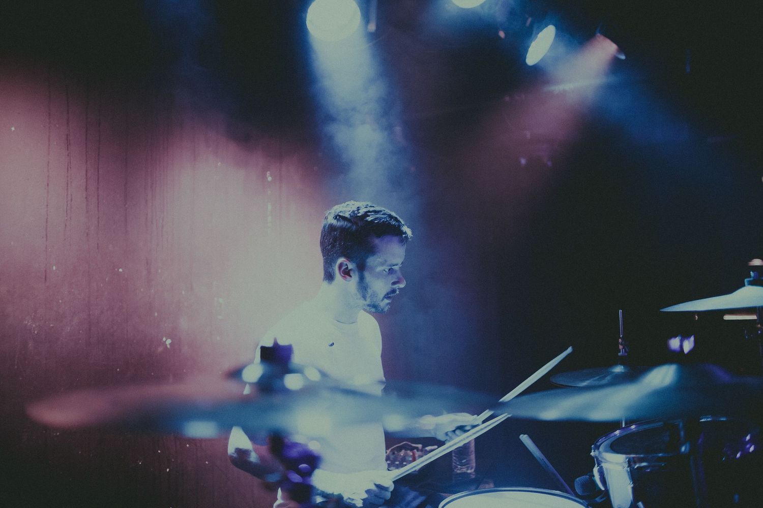 Blue and purple concert lighting creates a moody atmosphere during a live performance.