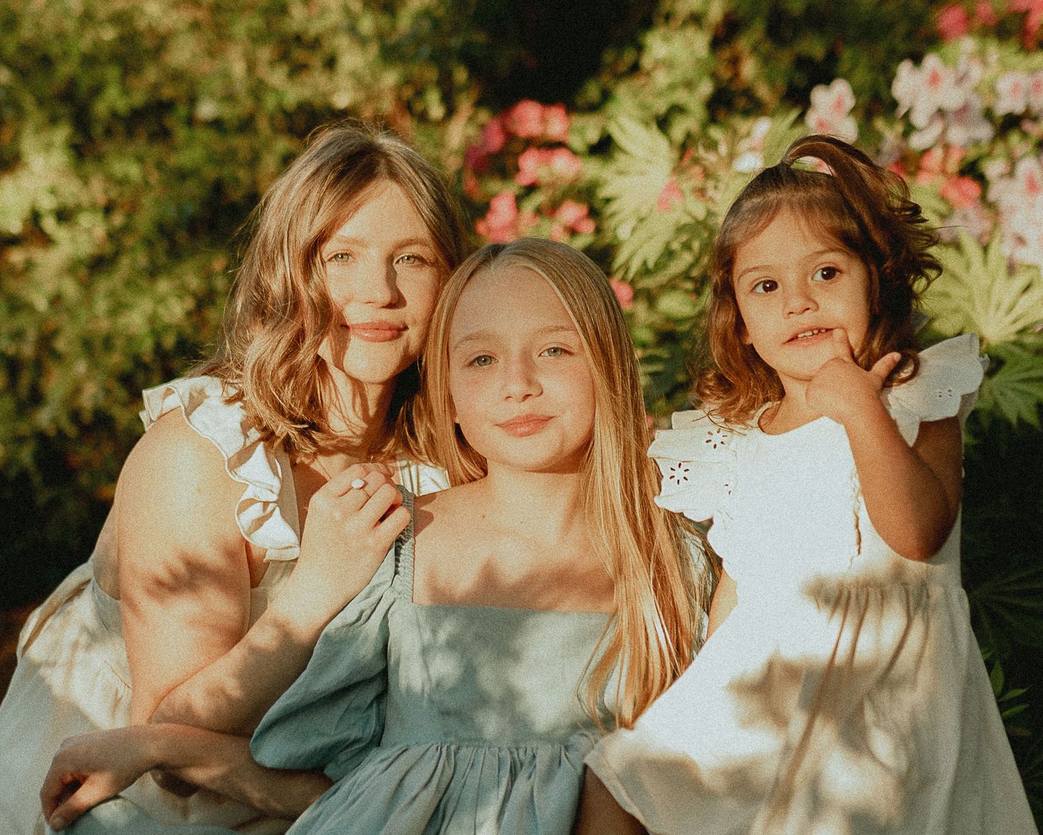 Candid portrait session in soft natural light with flowing dresses and garden backdrop.
