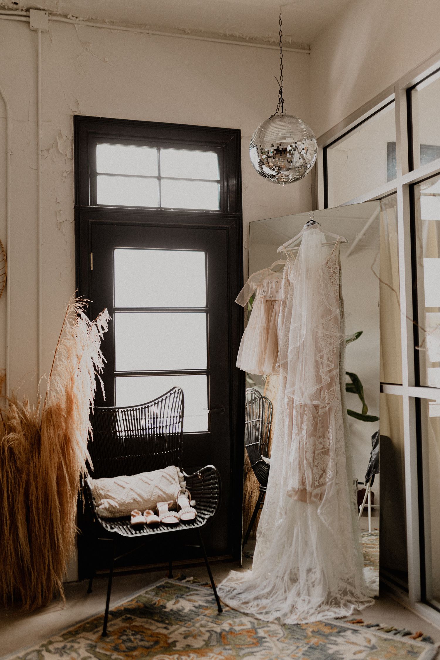 Wedding dresses with unique ombre dip-dyed details hang in a bright, minimalist room.