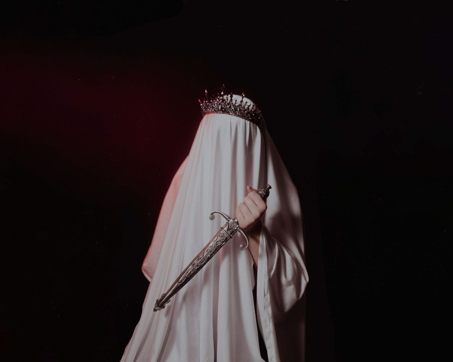Ethereal silhouette of flowing white dress against dark background.