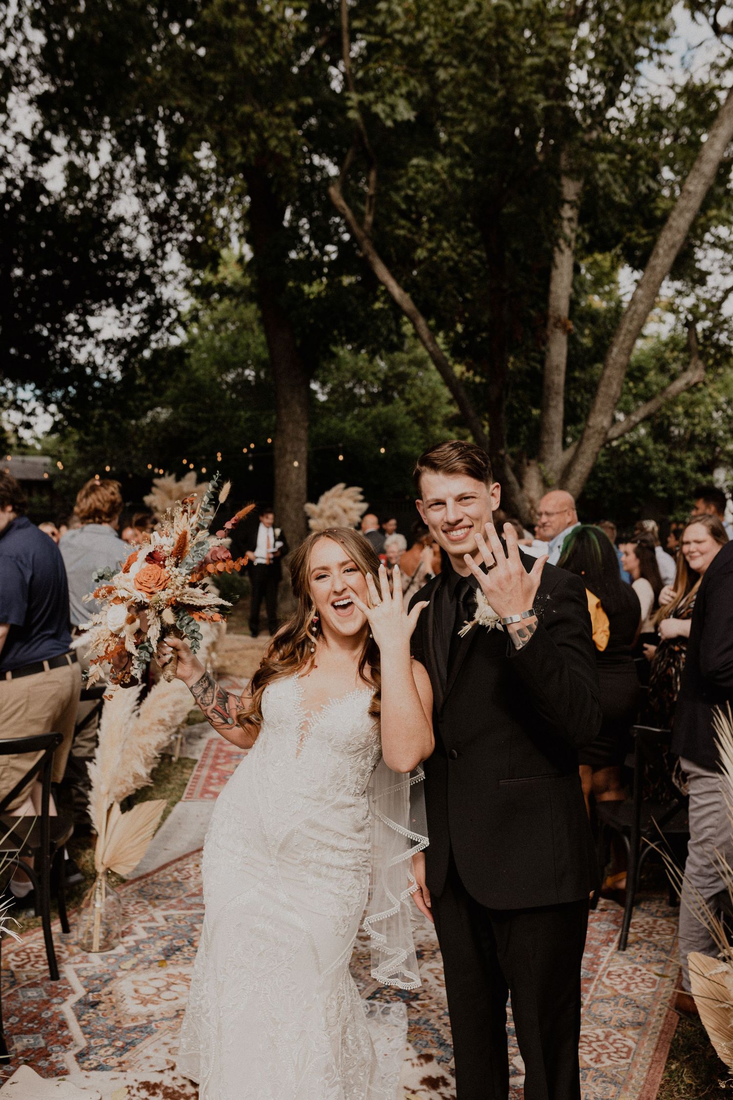 Wedding celebration outdoors with guests and wedding party amid natural scenery.
