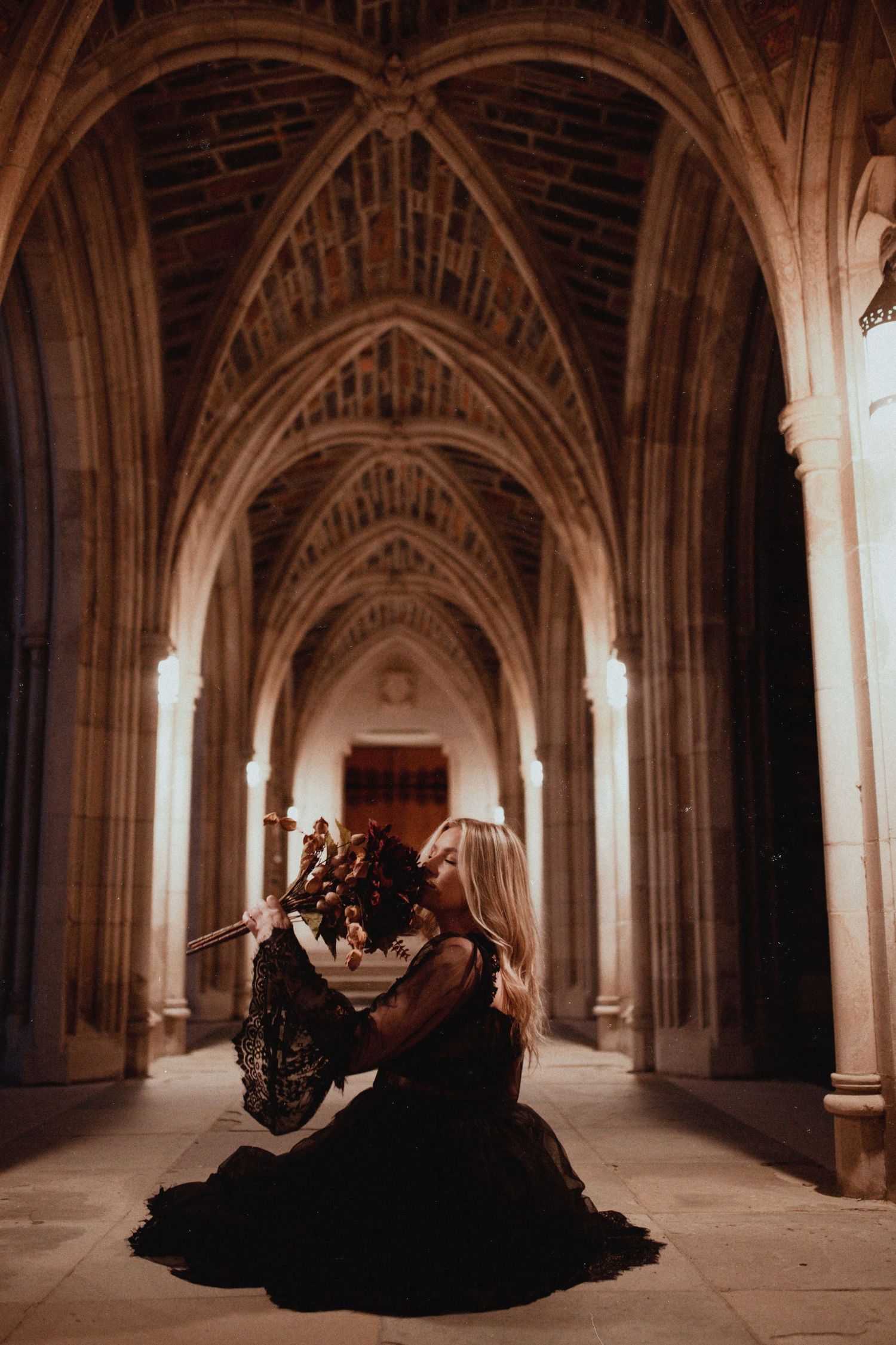 Gothic stone archway corridor with dramatic lighting creates moody architectural atmosphere.
