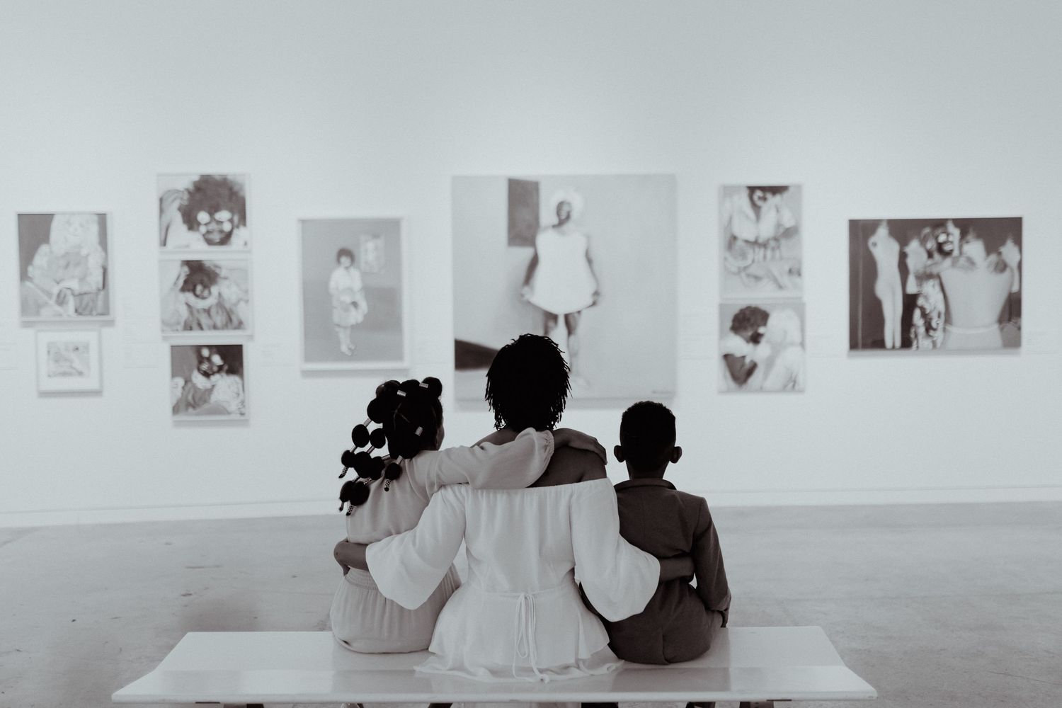 People viewing artwork displayed on white gallery walls in minimalist space.