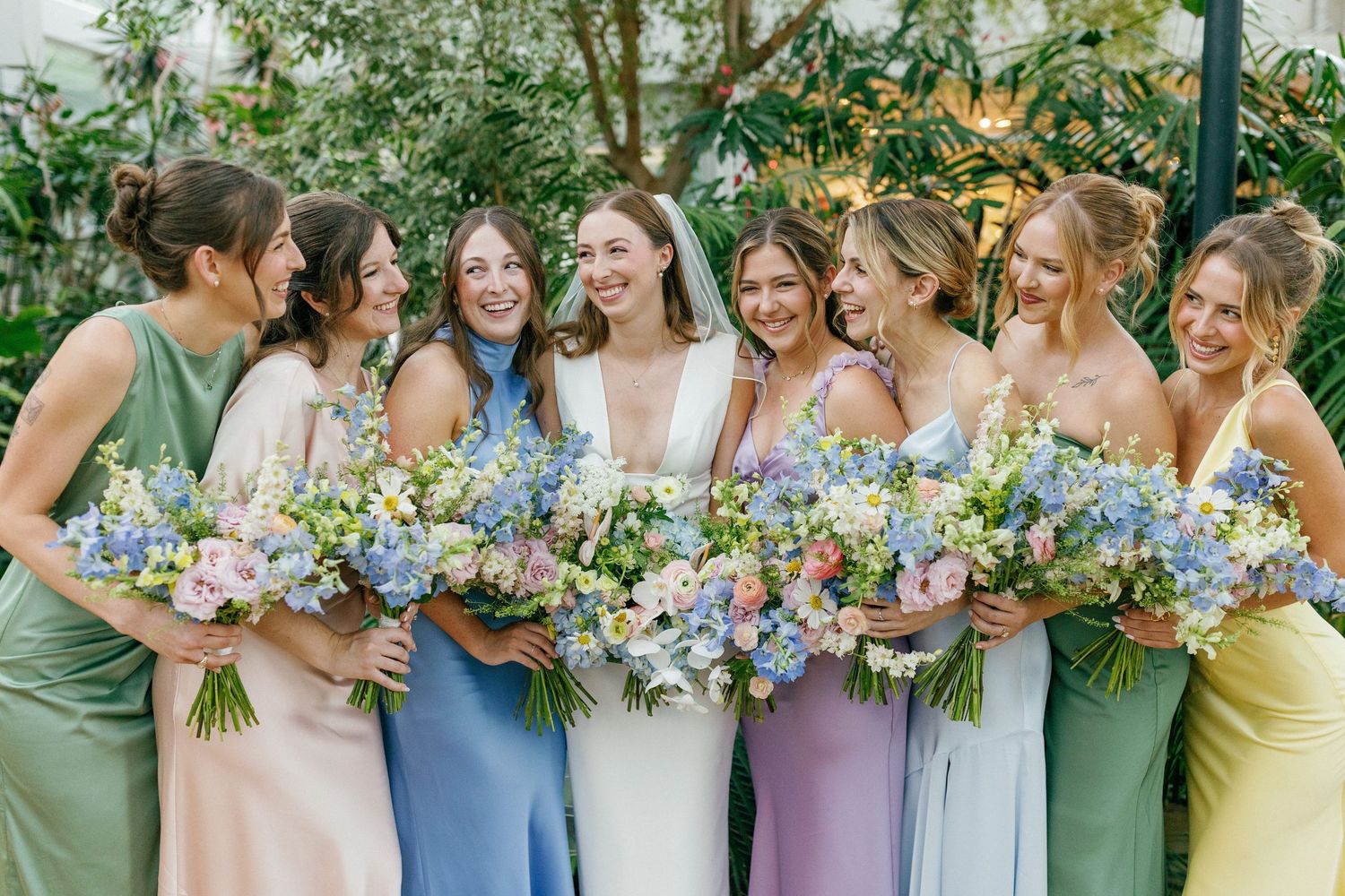 Bride laughing with bridesmaids in dresses before ceremony