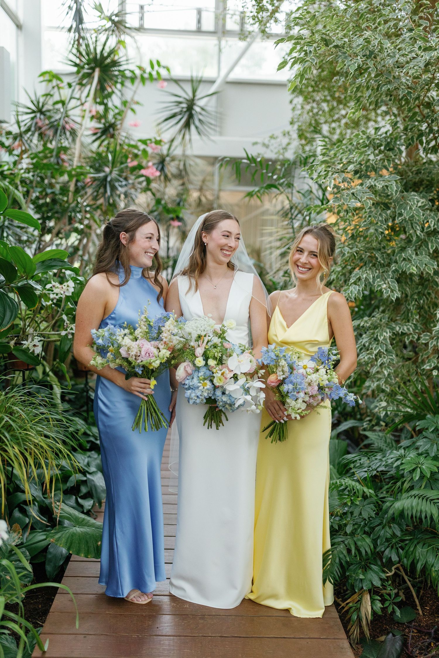 Bride laughing with bridesmaids in dresses before ceremony