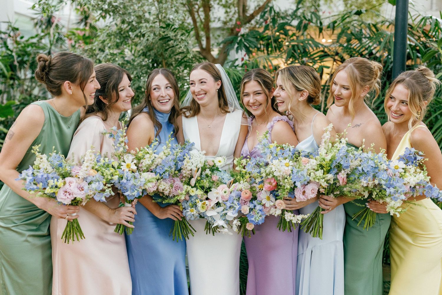 Bride laughing with bridesmaids in dresses before ceremony