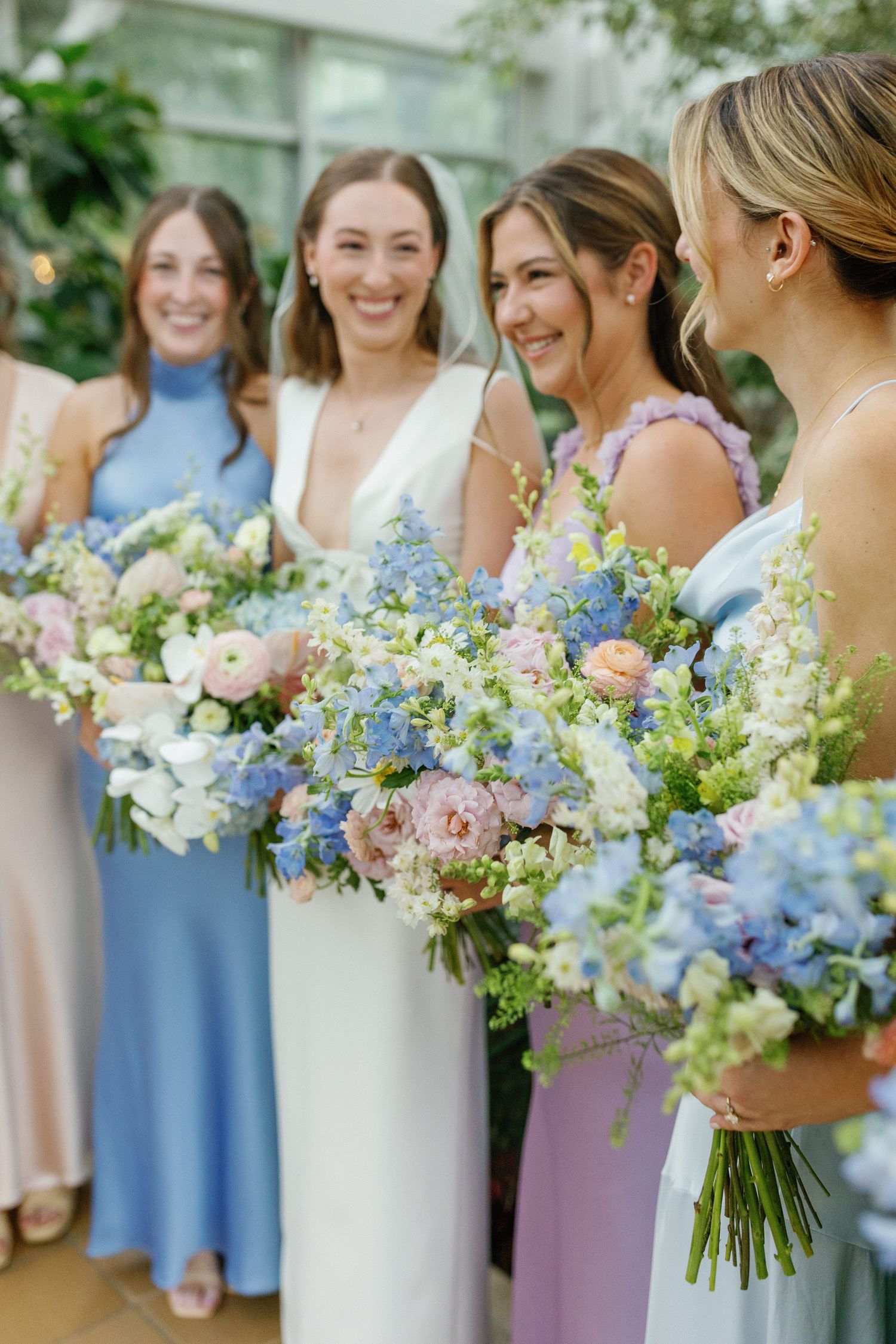 Bride laughing with bridesmaids in dresses before ceremony