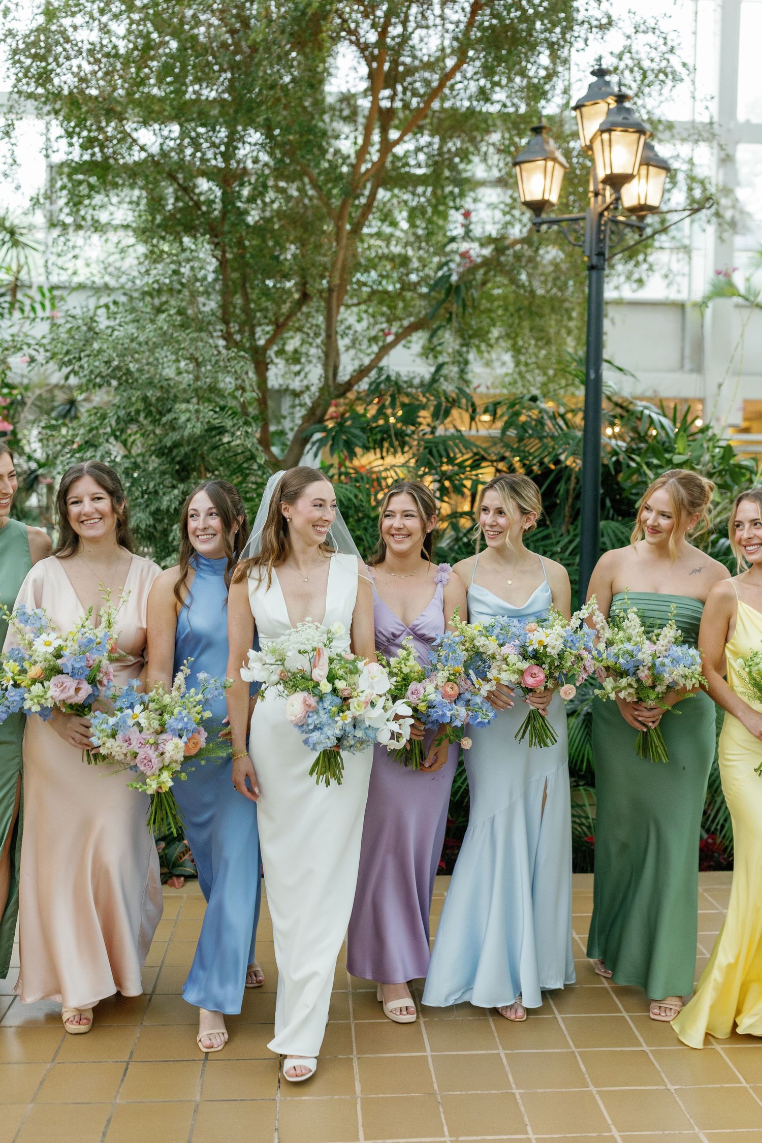 Candid photo of bridesmaids laughing while walking with bride