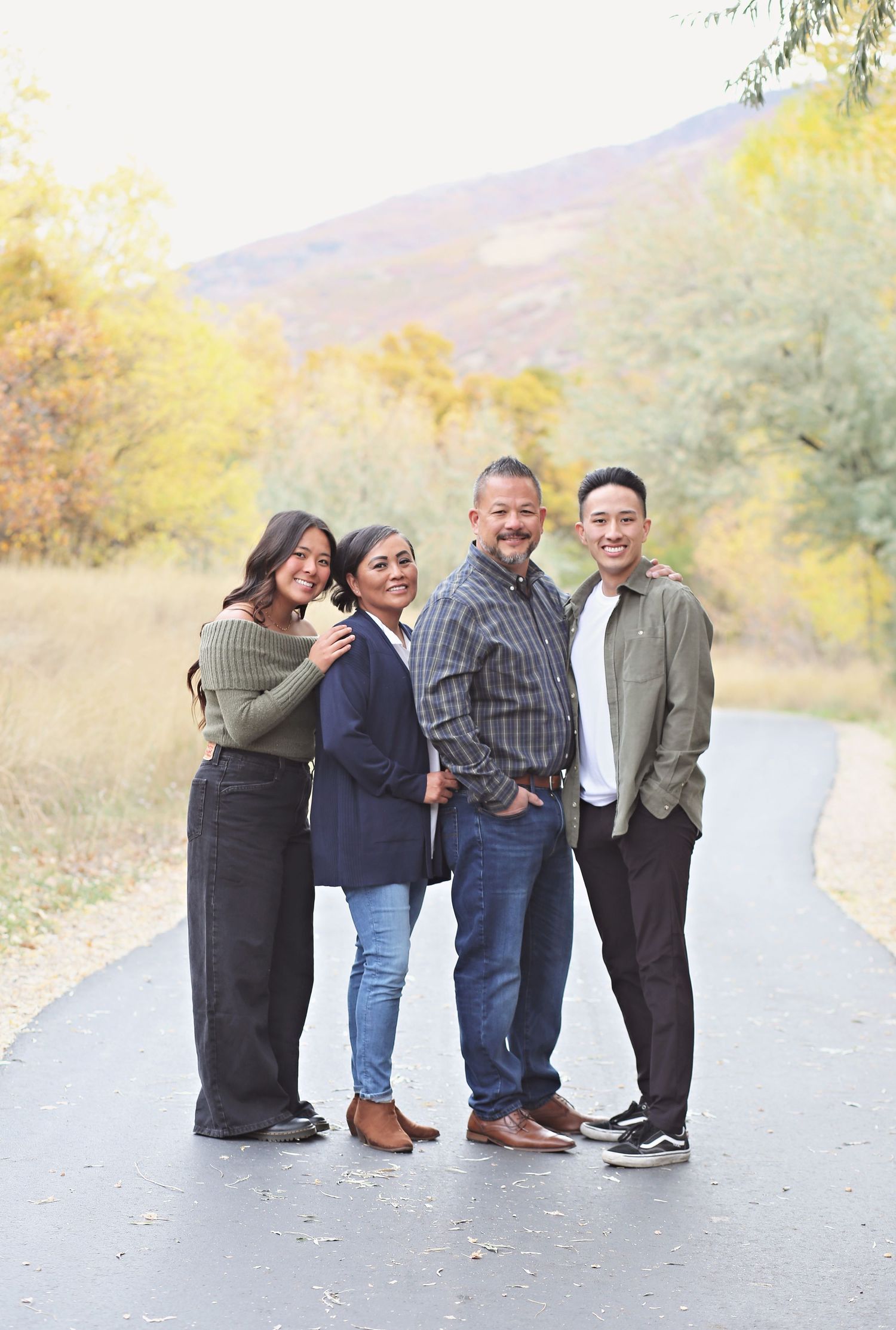 Group stands close together on desert path during outdoor family photo session.