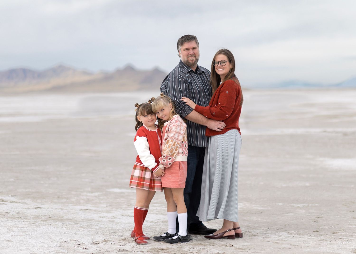 A group poses together on the white salt flats during a desert photoshoot.
