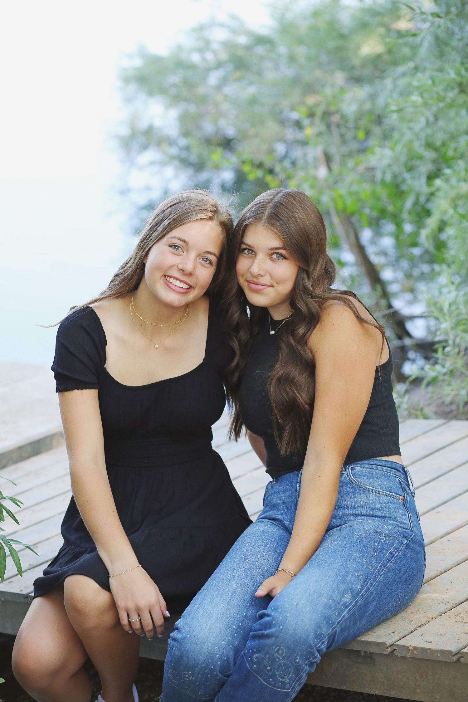 Casual outdoor portrait session on a wooden deck featuring coordinated black and denim outfits.