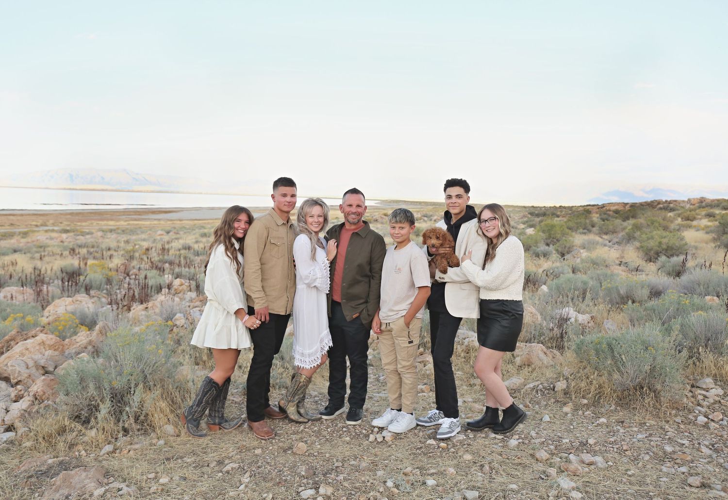 Family group photo session in desert terrain with mountains and sagebrush in background.