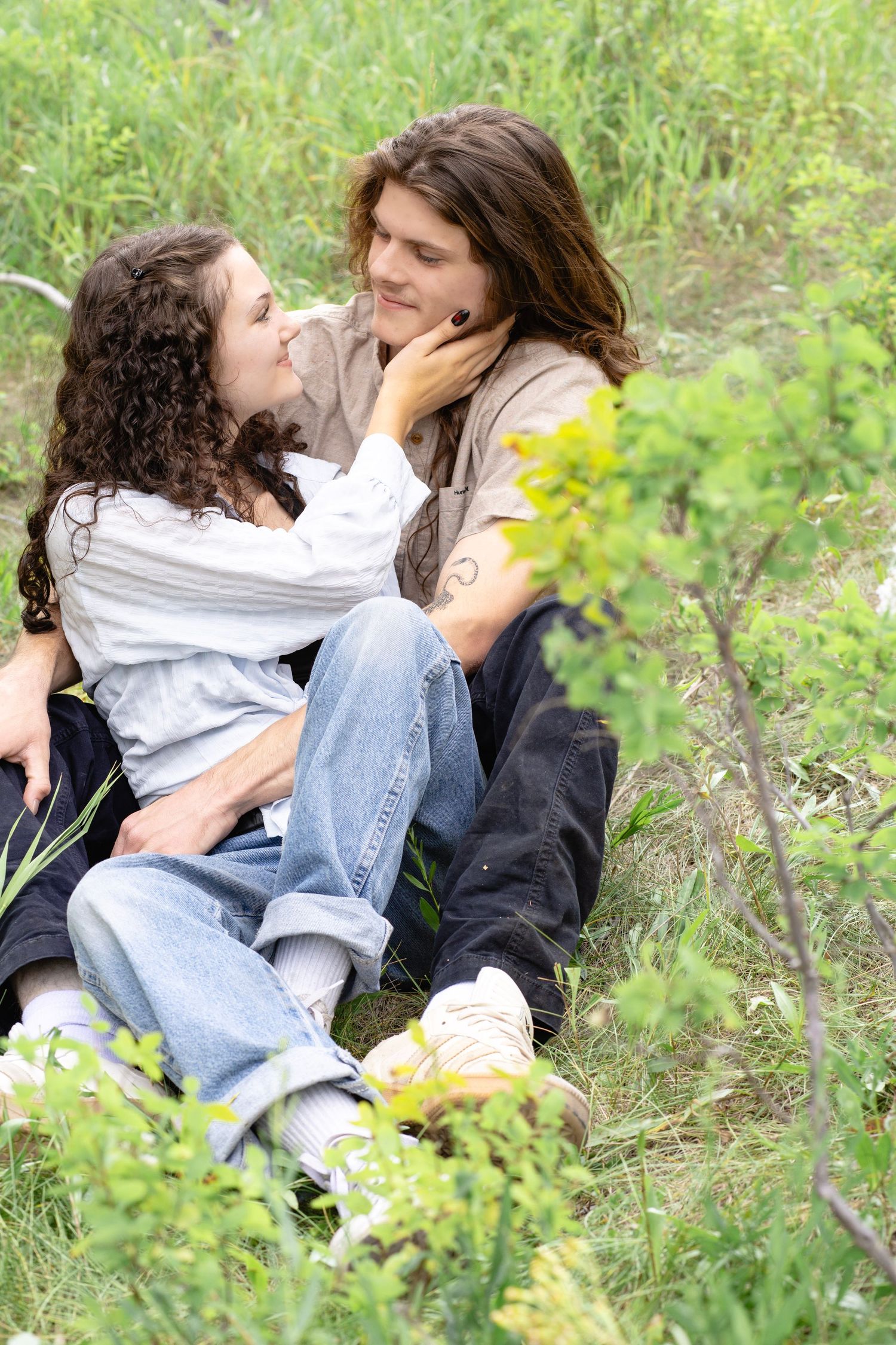Romantic couple photoshoot among wildflowers and natural greenery.