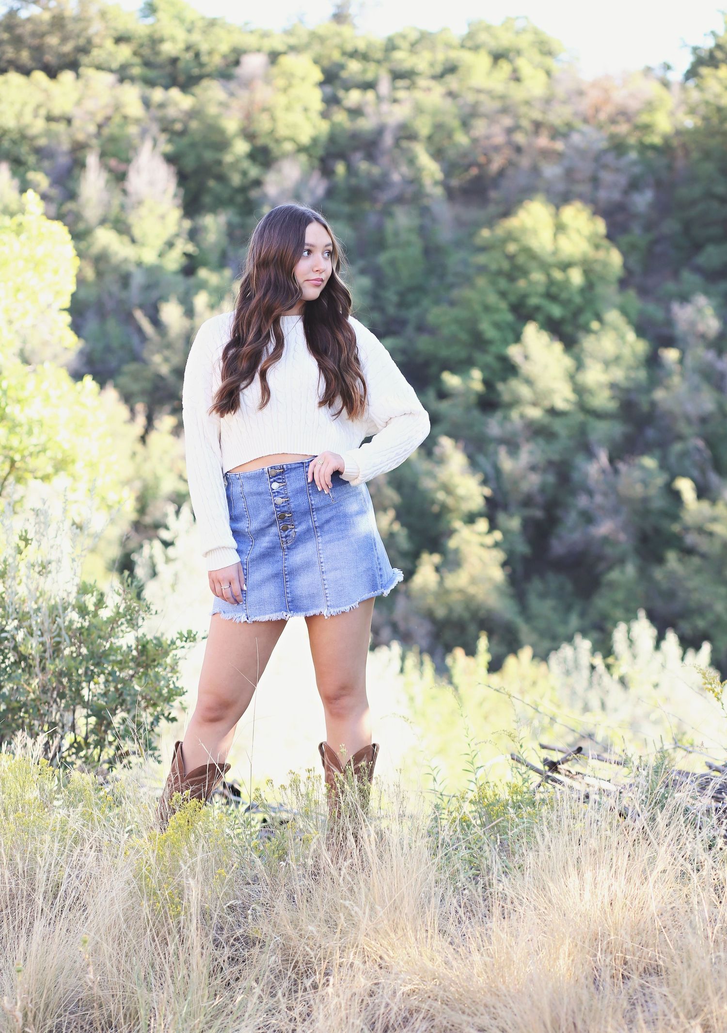 Fashion portraits in denim skirt and white top against natural foliage.