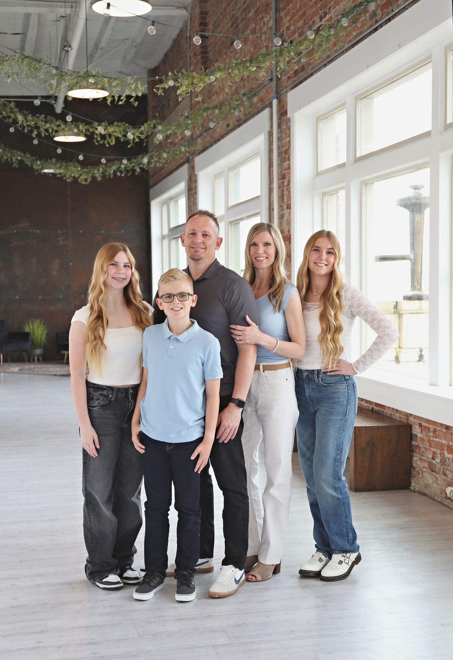 Family members' legs and feet shown in a creative photography series against a white brick wall interior.