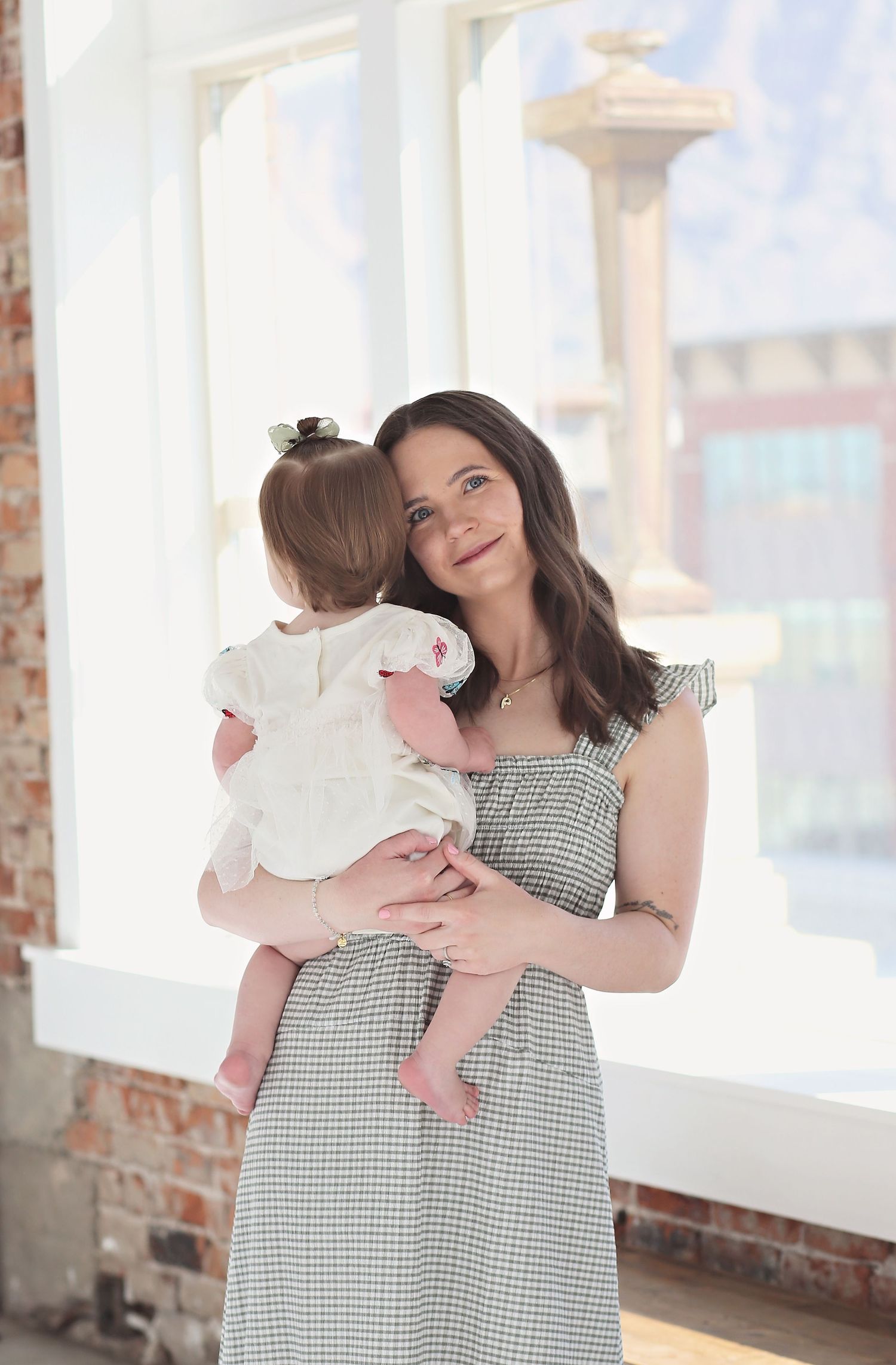 A tender moment between parent and child in a bright industrial-style room.