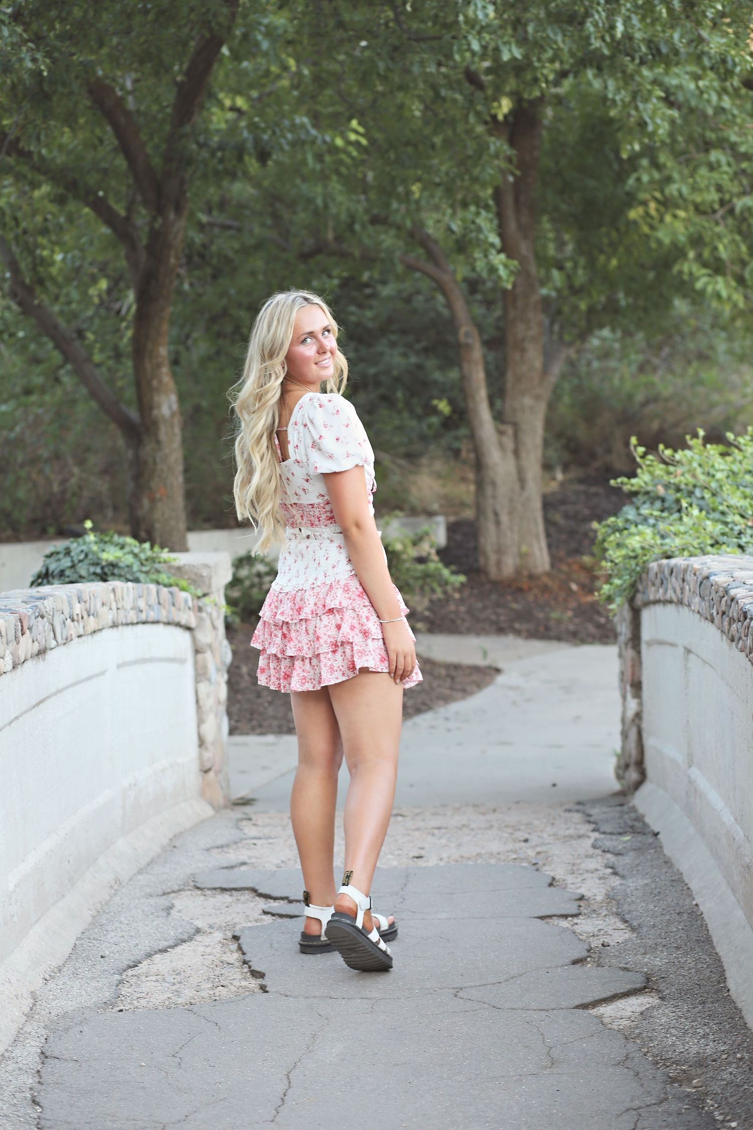 Series of casual poses along a curved stone path surrounded by trees.