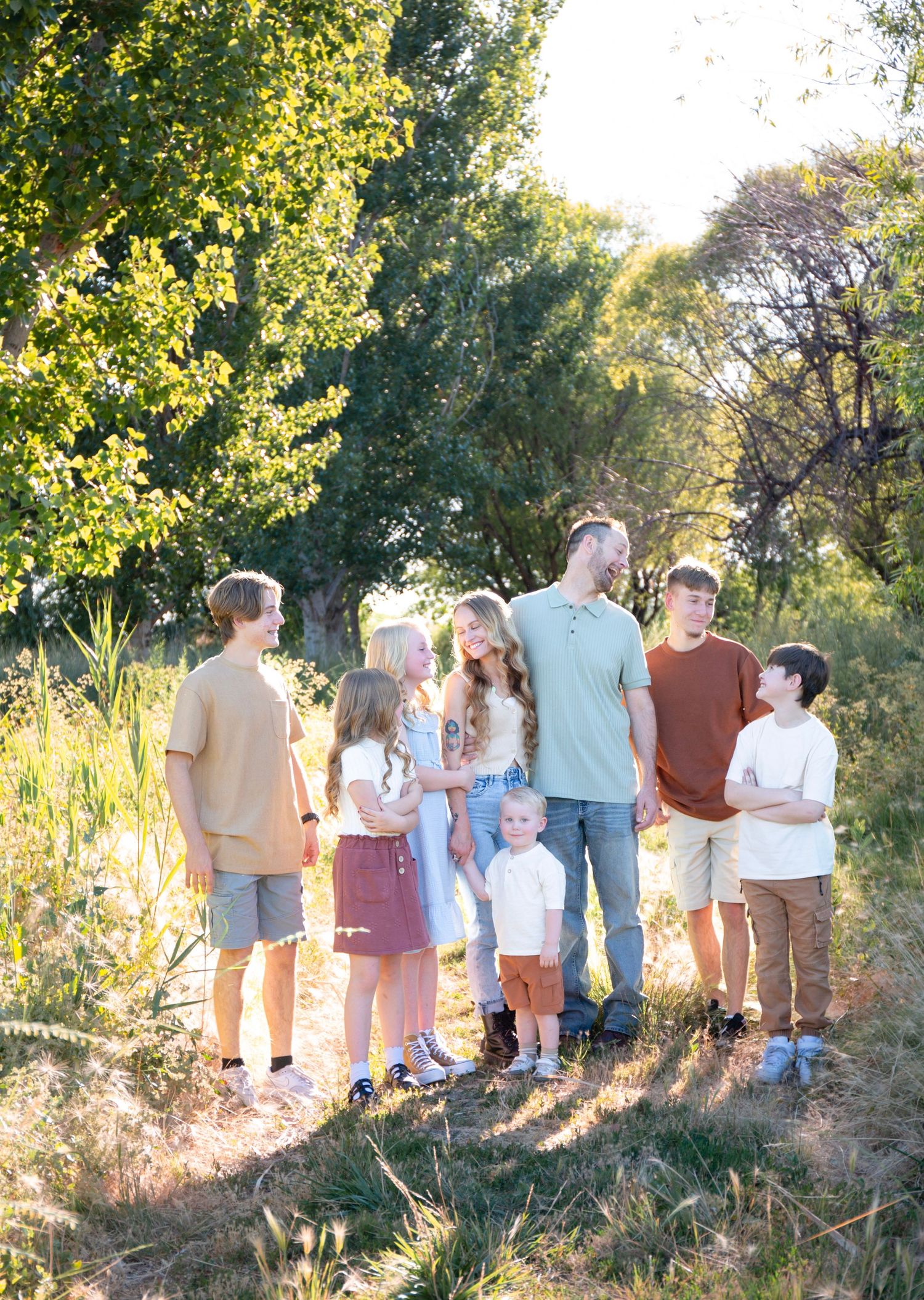 A group stands together on a hillside path surrounded by trees and natural vegetation.