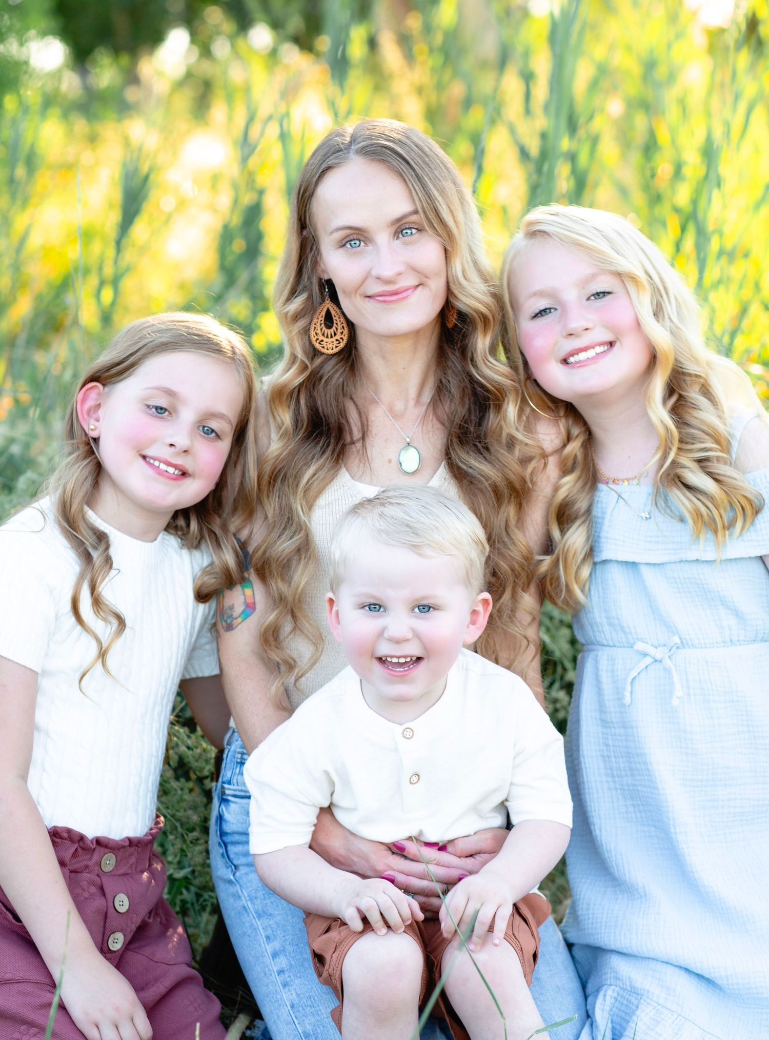Family portrait showing joyful expressions in a sunny outdoor setting with yellow flowers.