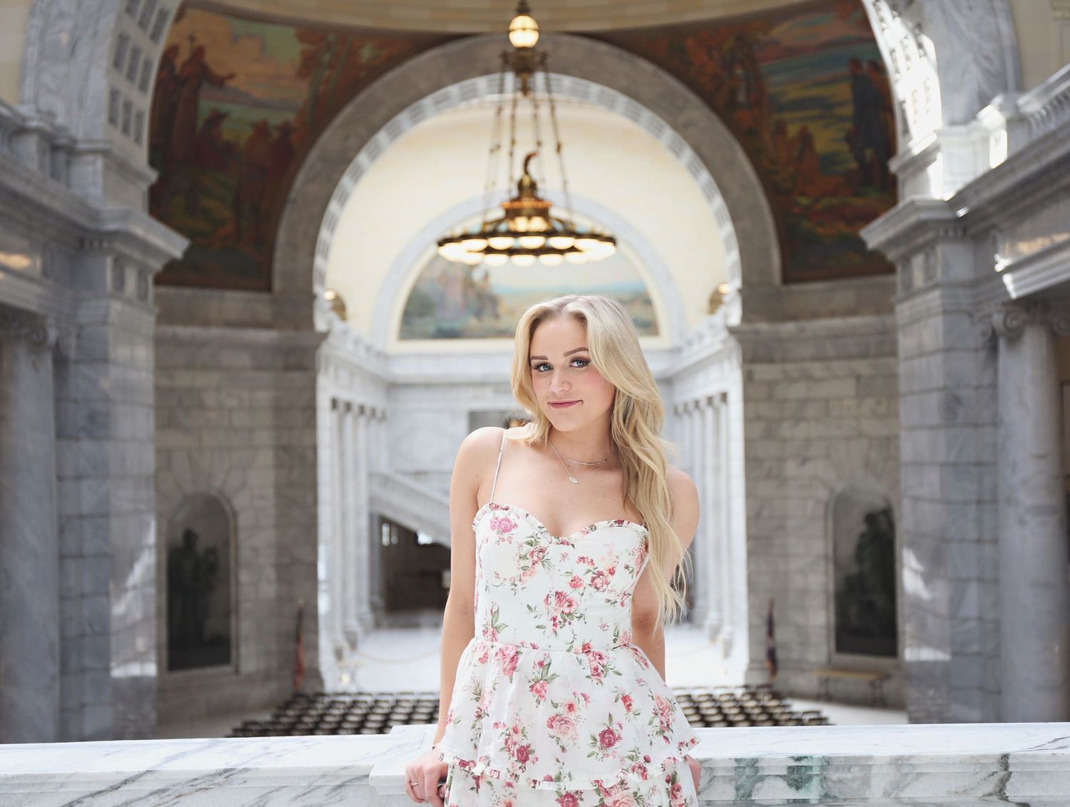 Portrait session in ornate classical architecture setting with arched ceilings and columns.
