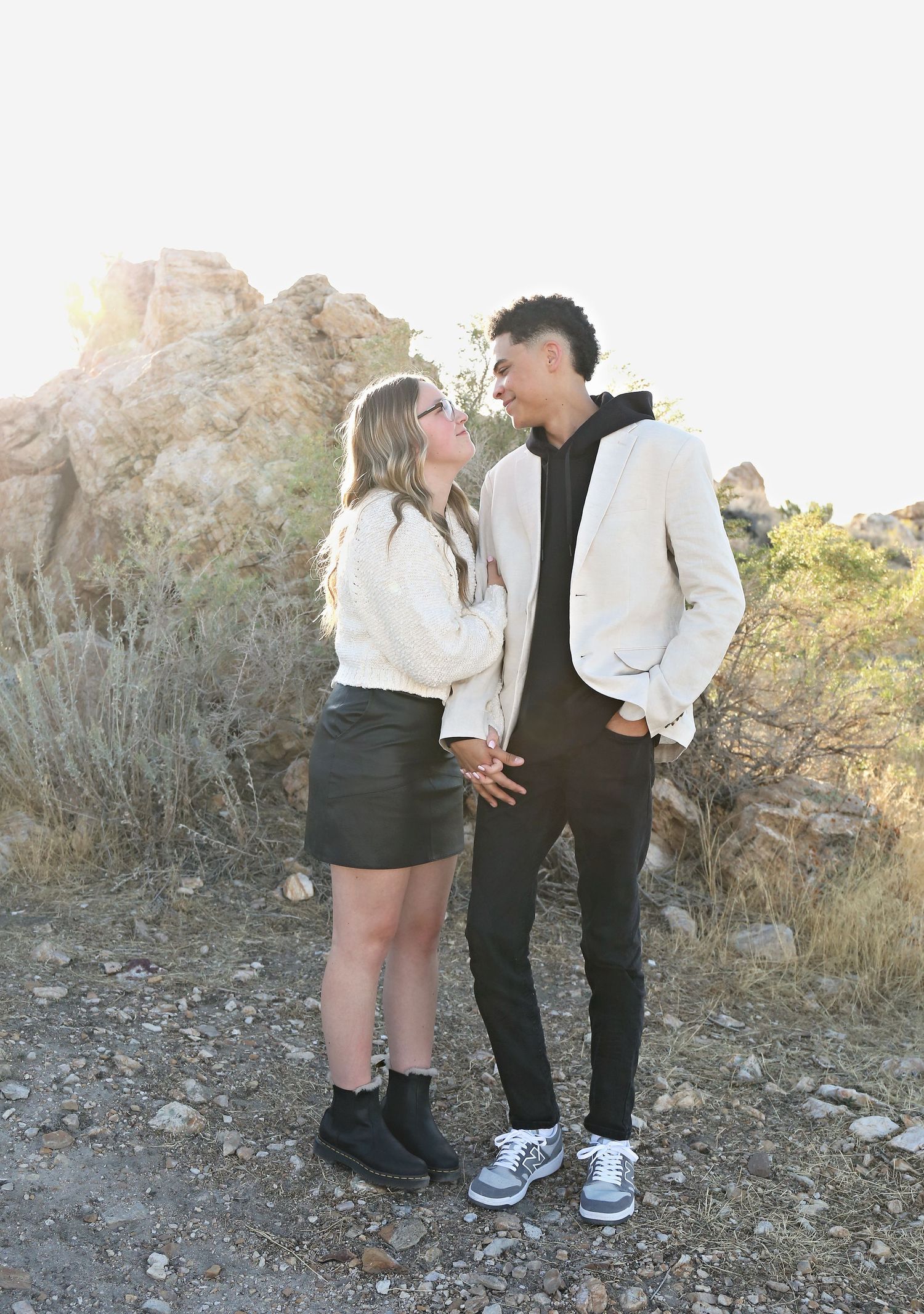 A couple shares a playful moment on a desert hiking trail.
