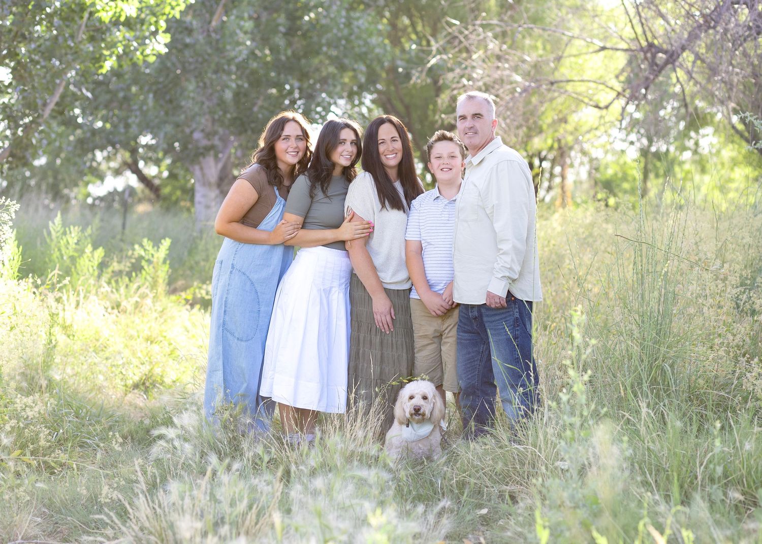 Group photo session in a scenic field with tall grass and natural lighting.