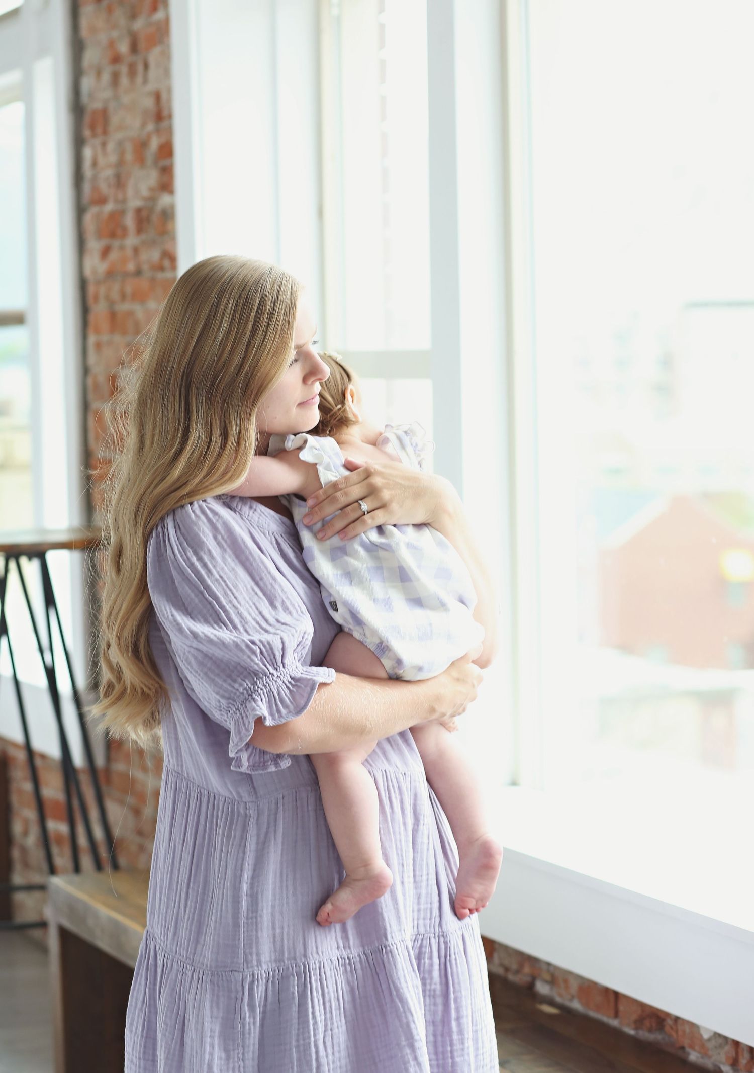 Tender moment captured in bright indoor setting with natural window light.