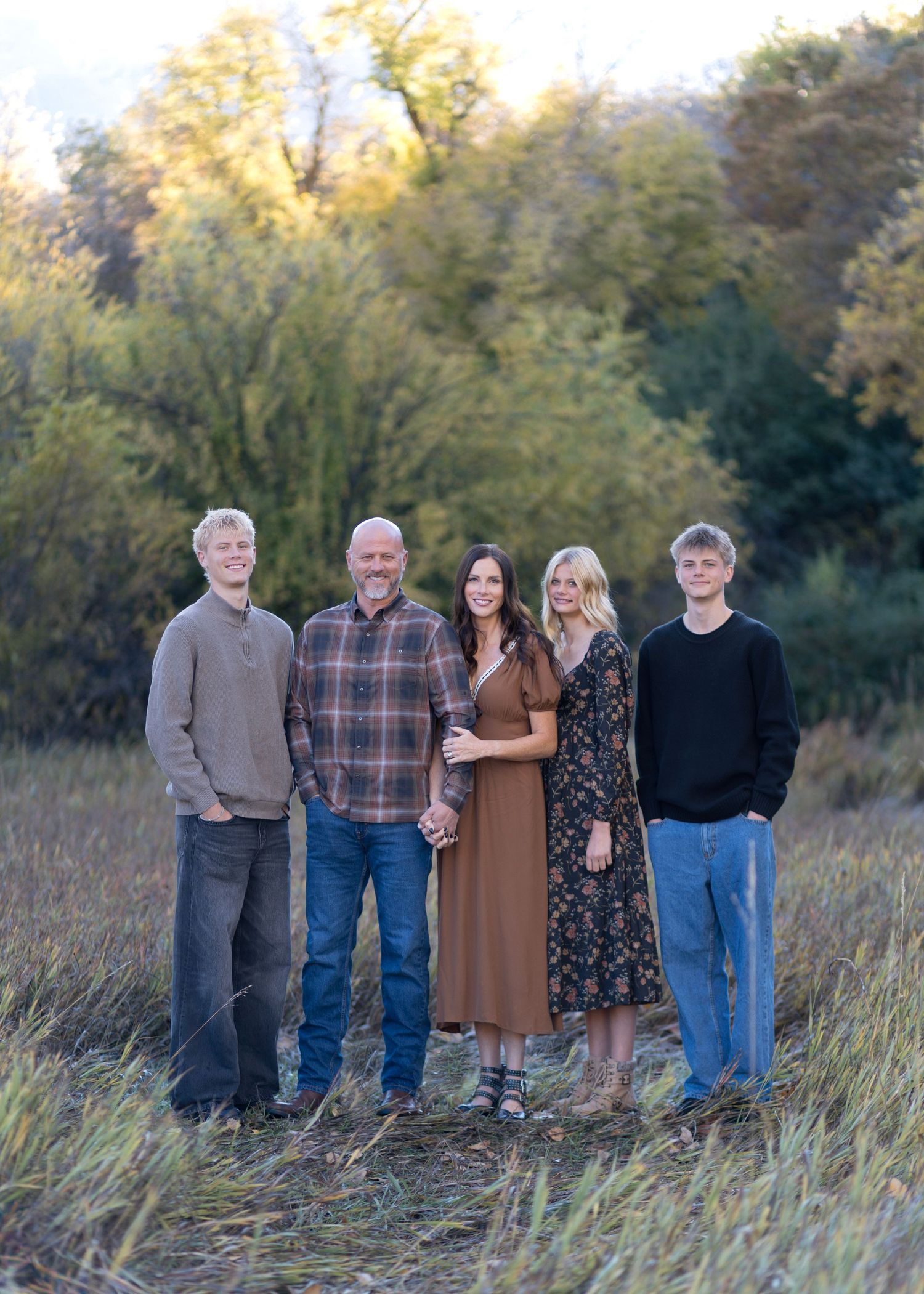 Group photo series in tall grass field during golden hour with casual fall outfits.