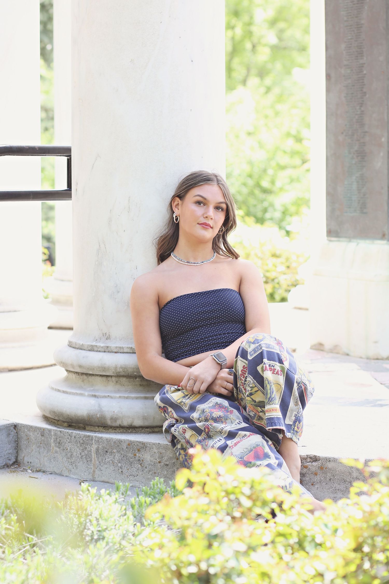 Artistic portrait series against white columns with flowering plants in the background.