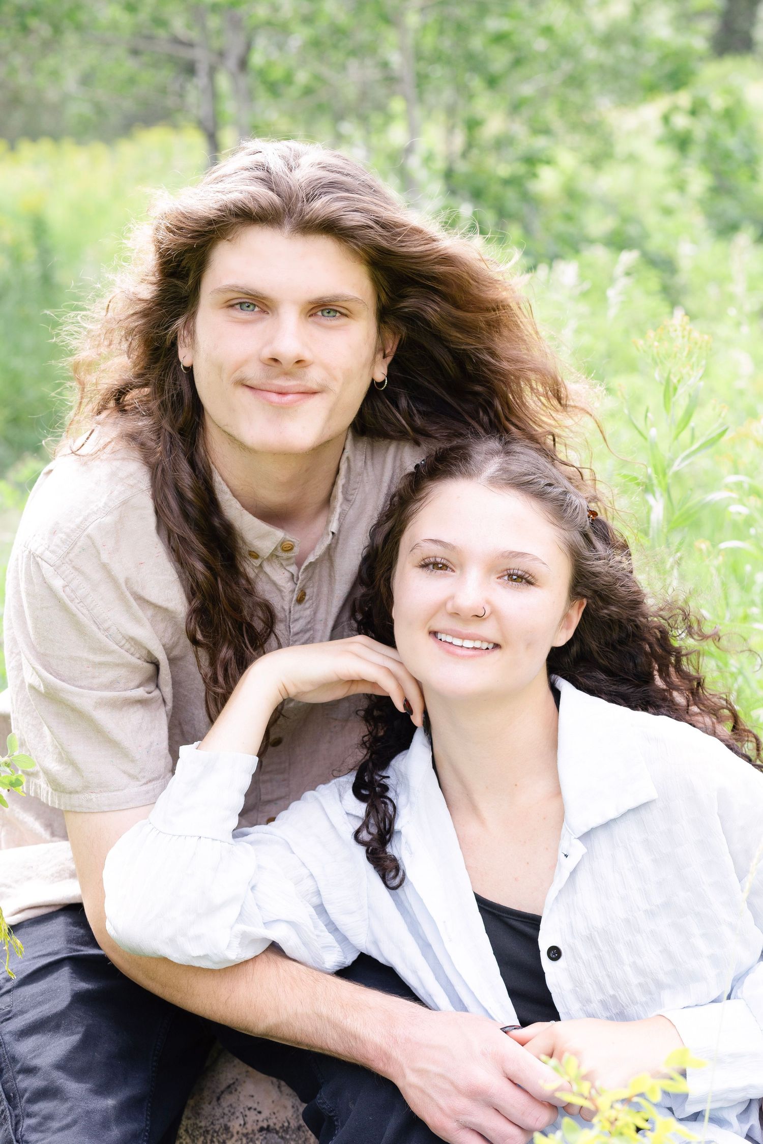 Intimate outdoor portrait session in a natural setting with soft lighting and greenery.