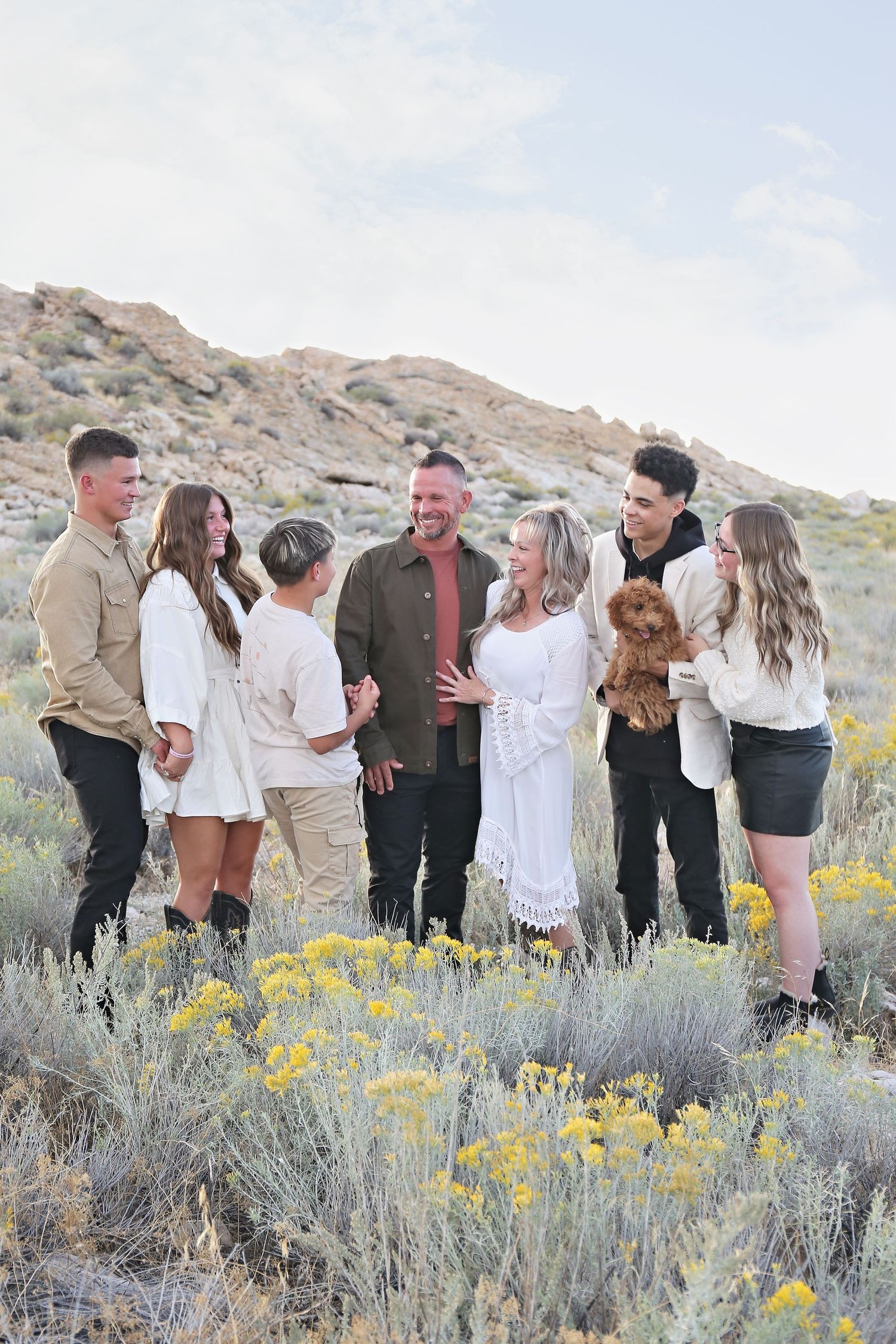 Candid group moments captured in desert landscape with blooming yellow wildflowers.
