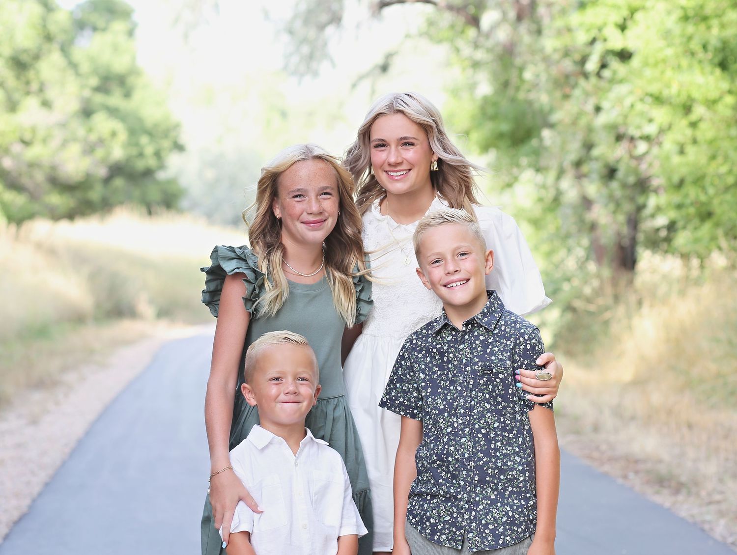 Candid family moments captured on nature trail with green foliage background.