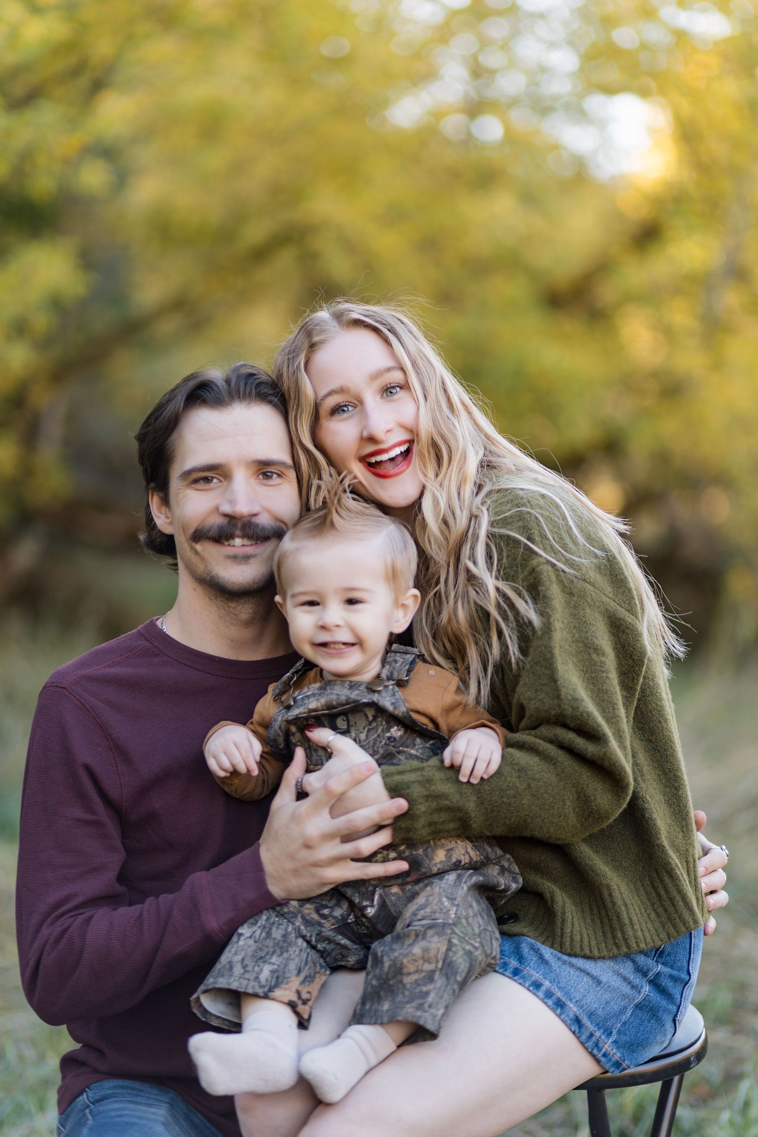 Family enjoying playful moments with their pet dog during an autumn photoshoot.