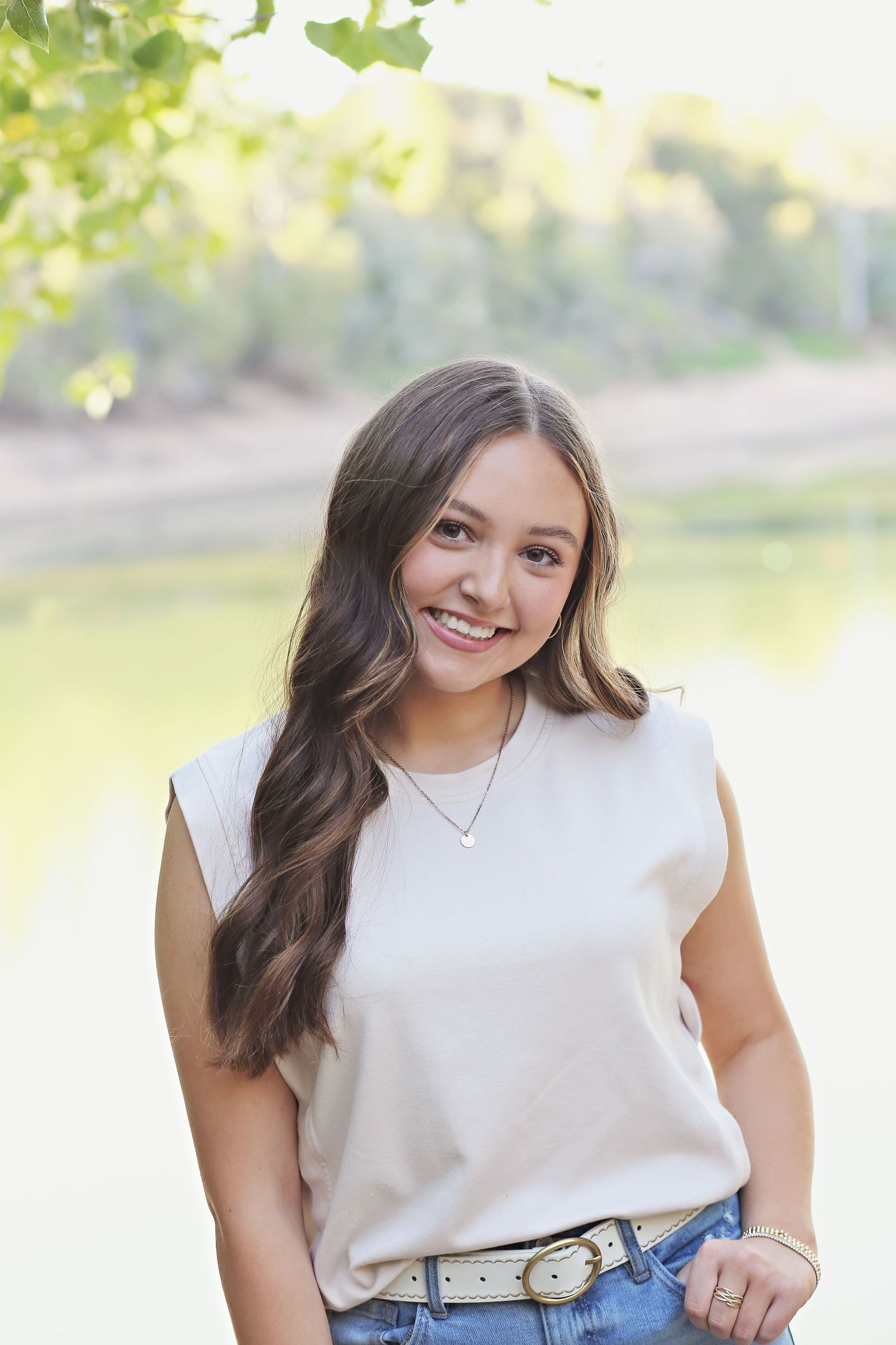 Casual summer portraits featuring a cream sleeveless top and natural outdoor setting.