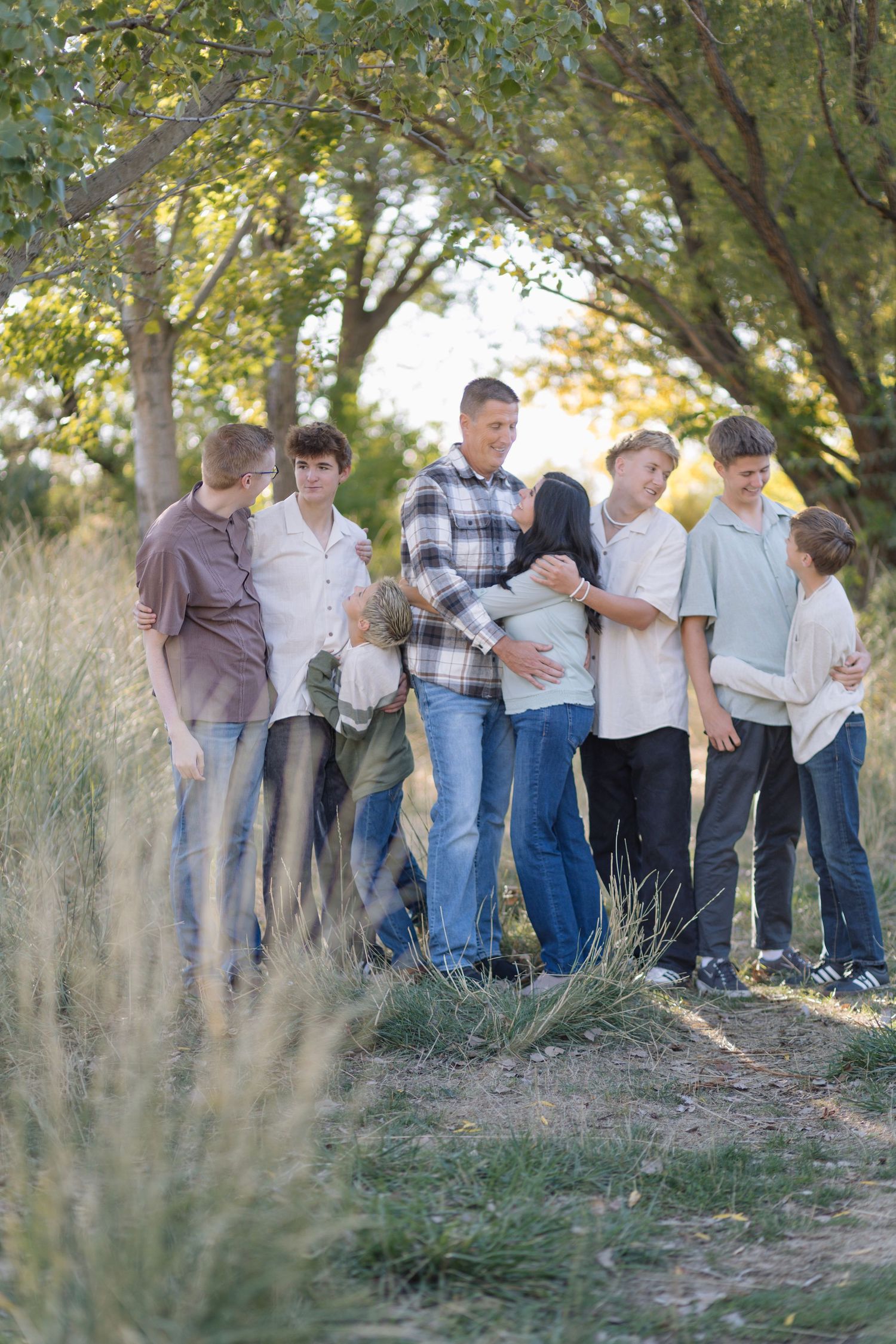 Large group of people lined up for casual outdoor family photos in tall grass.