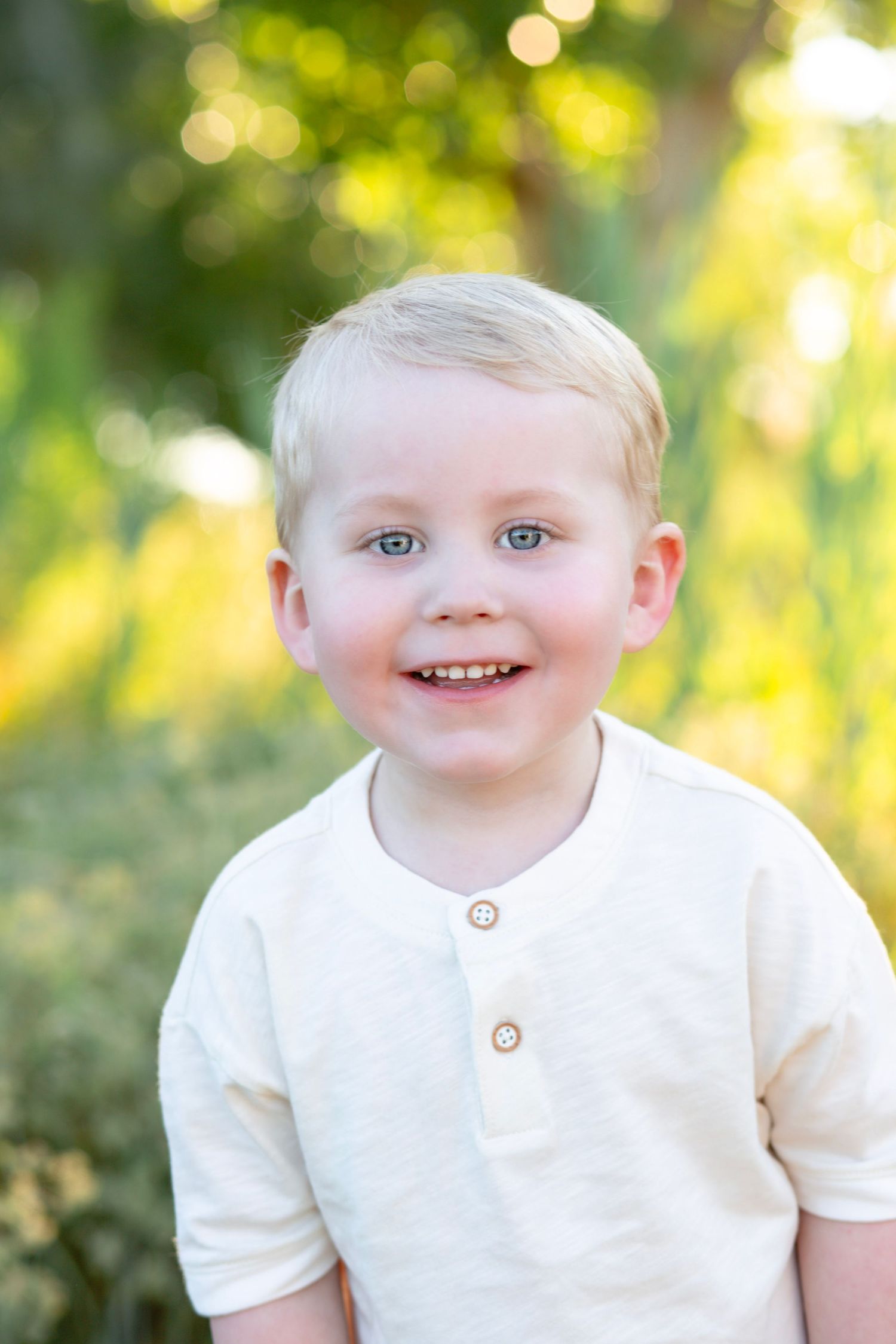 Close-up portrait with bright smile and bokeh lighting effects in background.