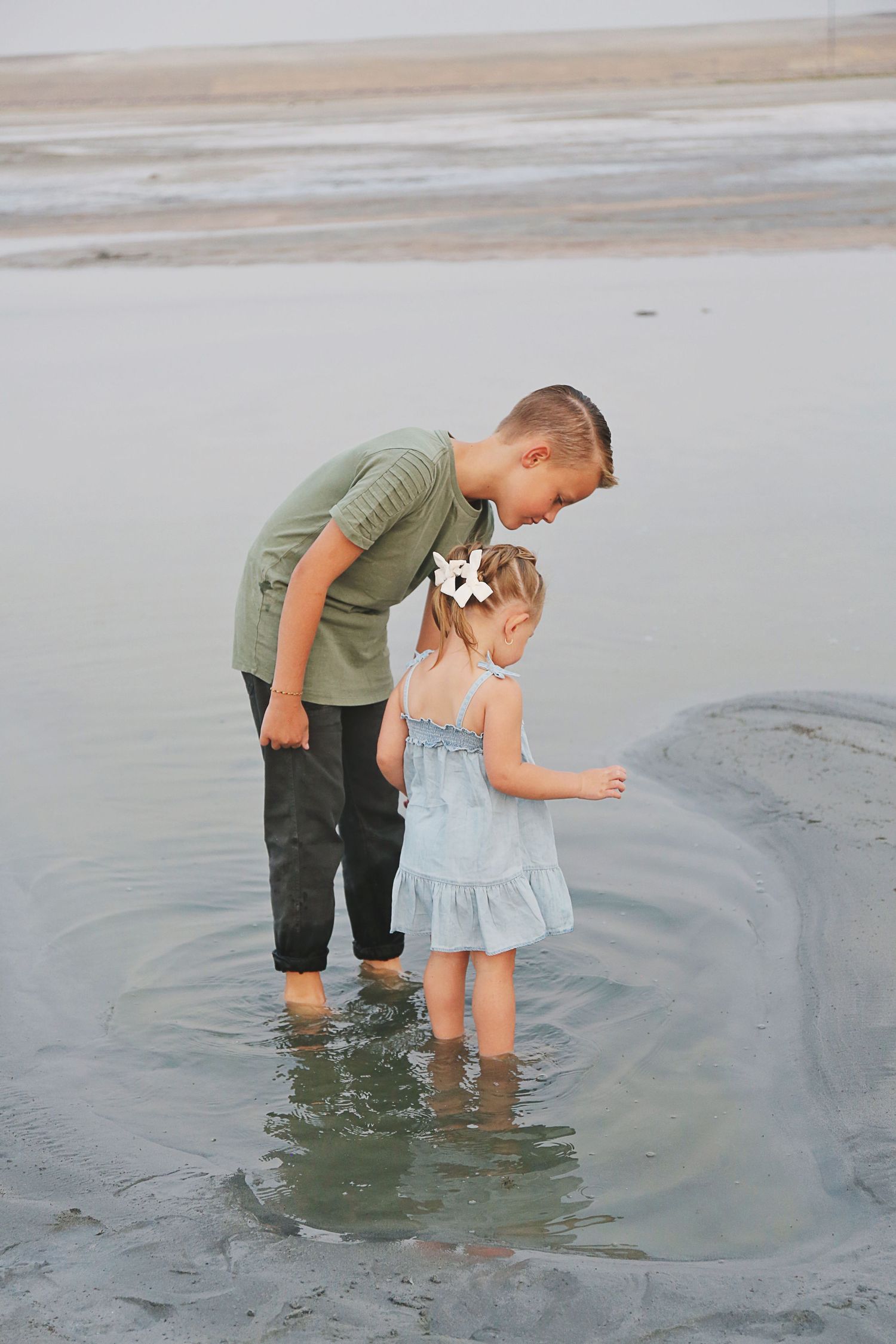 A sequence of photos showing people exploring tidal pools at the beach during sunset.