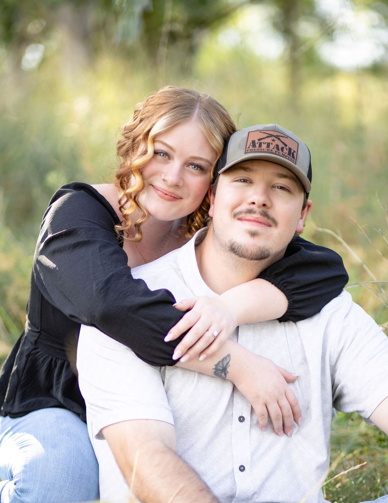 Candid outdoor portrait showing affectionate embrace against natural background.