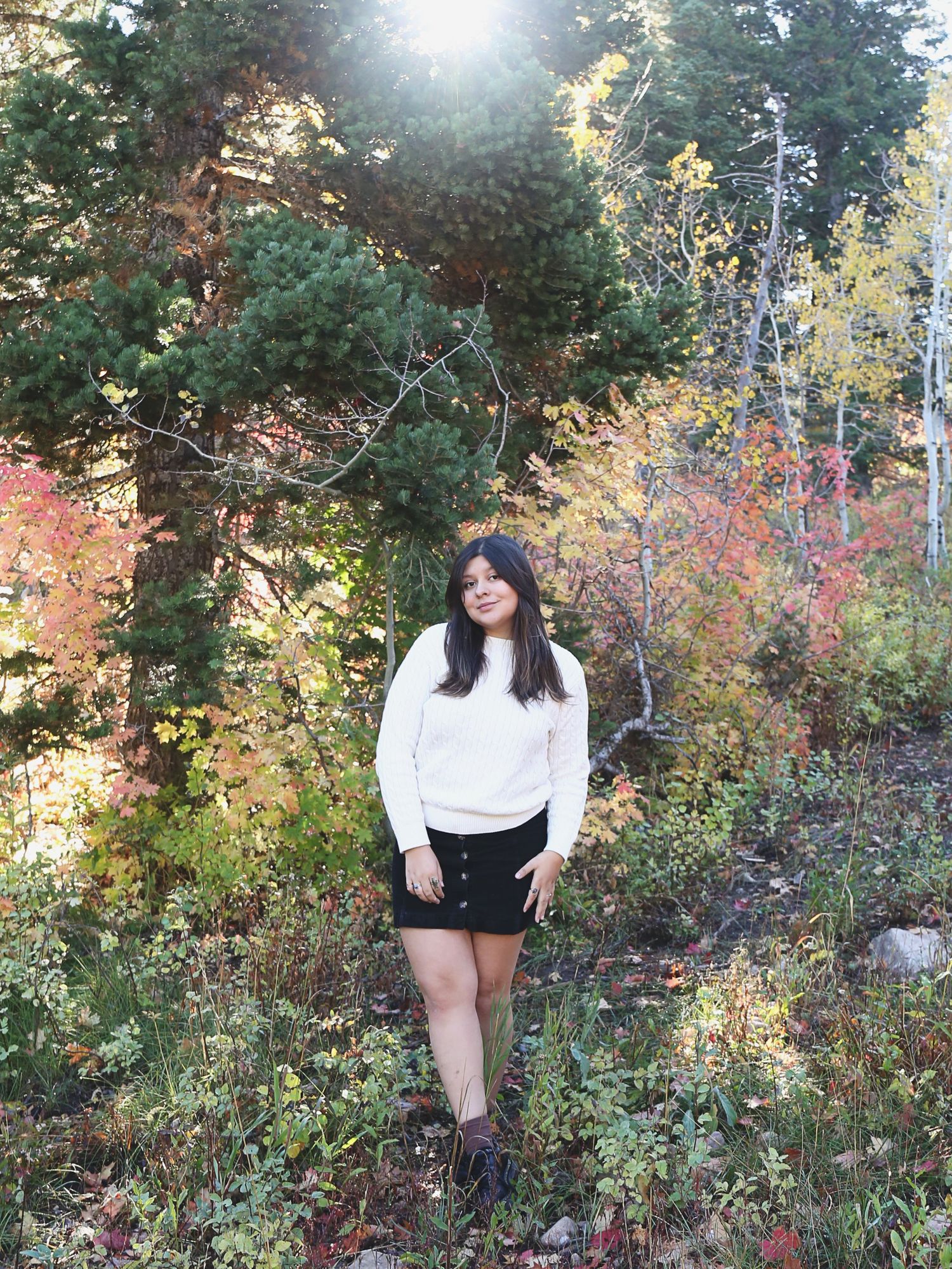 Black and white outfit photographed among colorful autumn foliage.