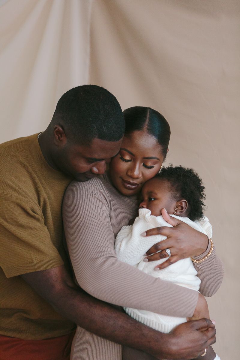 Family embracing sweetly in studio, NYC family photography by Paula Brearley NYC family photographer