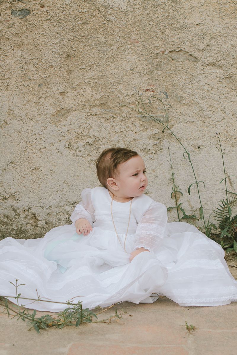 Baby in baptism gown during NYC ceremony, photographed by Paula Brearley NYc baptism photographer