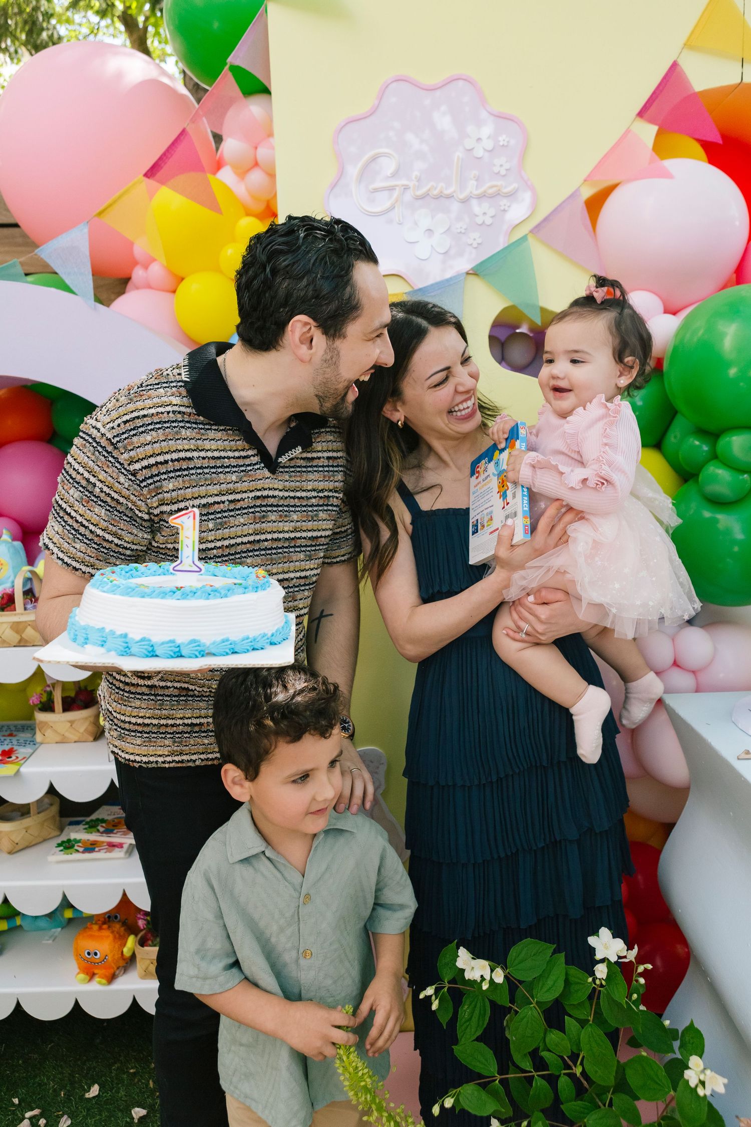 Family of four blowing birthday candles, candid NYC photography by Paula Brearley NYC birthday party photographer
